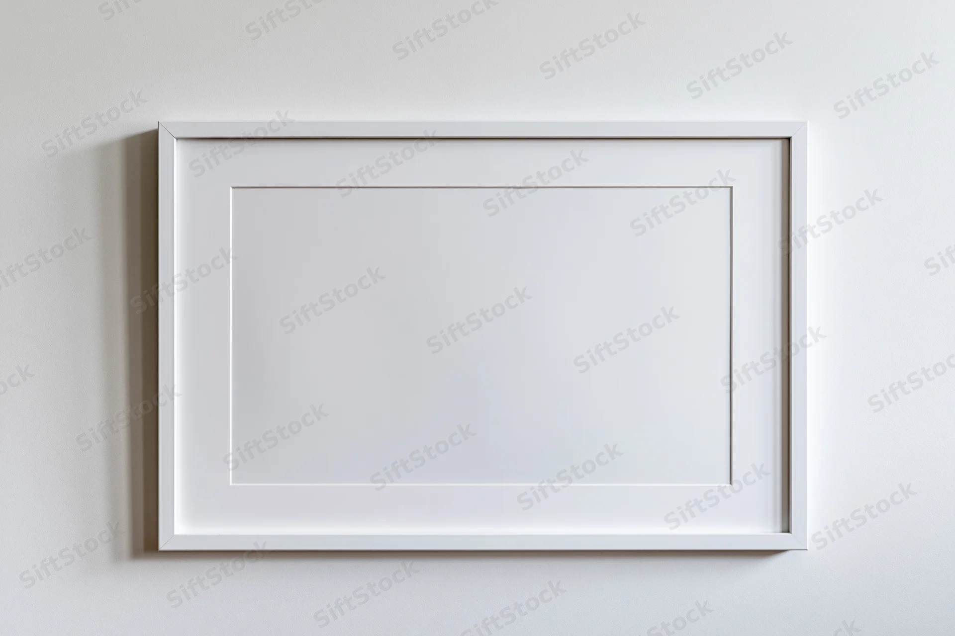 White picture frame with mat border hanging on a plain wall