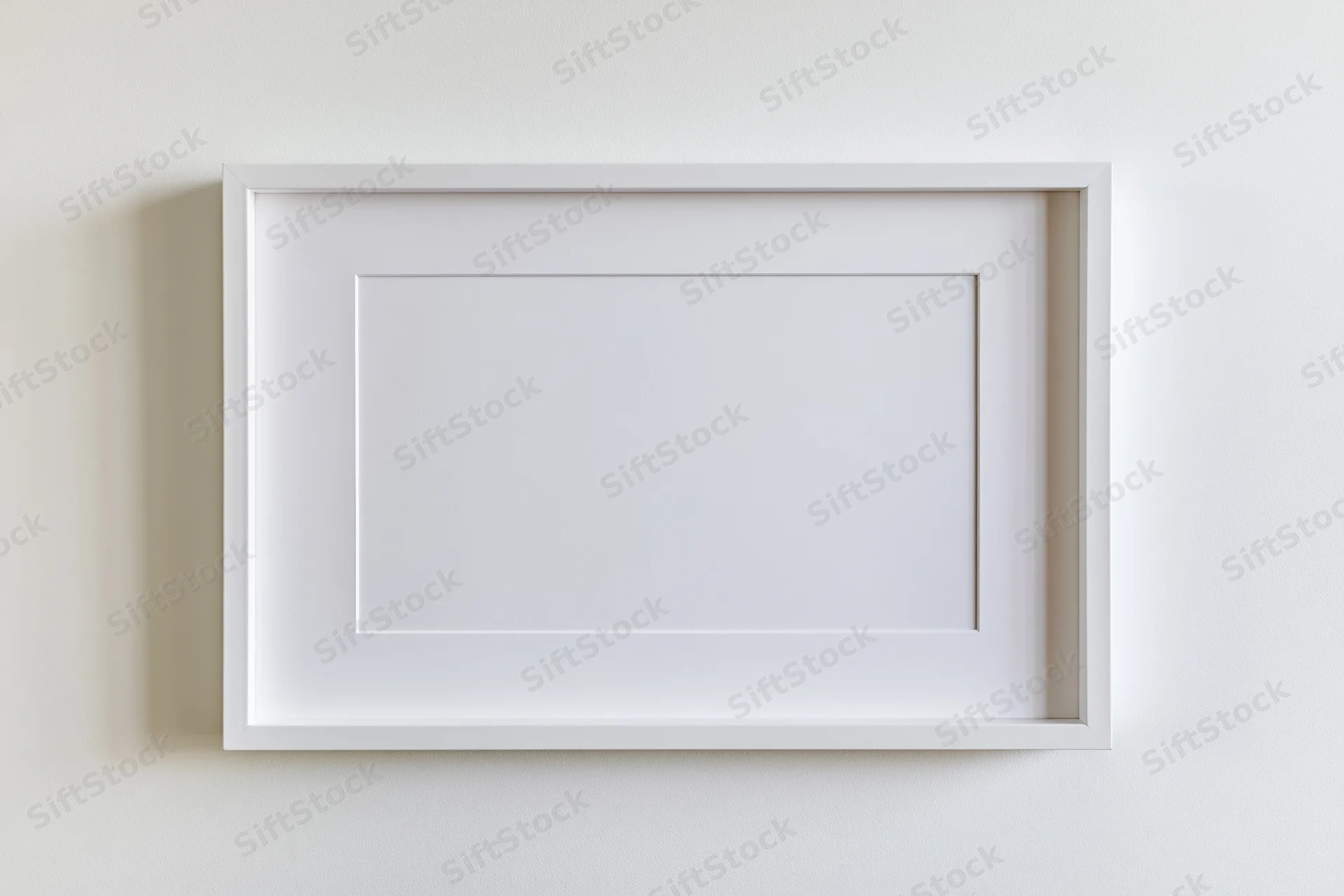 White picture frame with mat border hanging on a plain wall