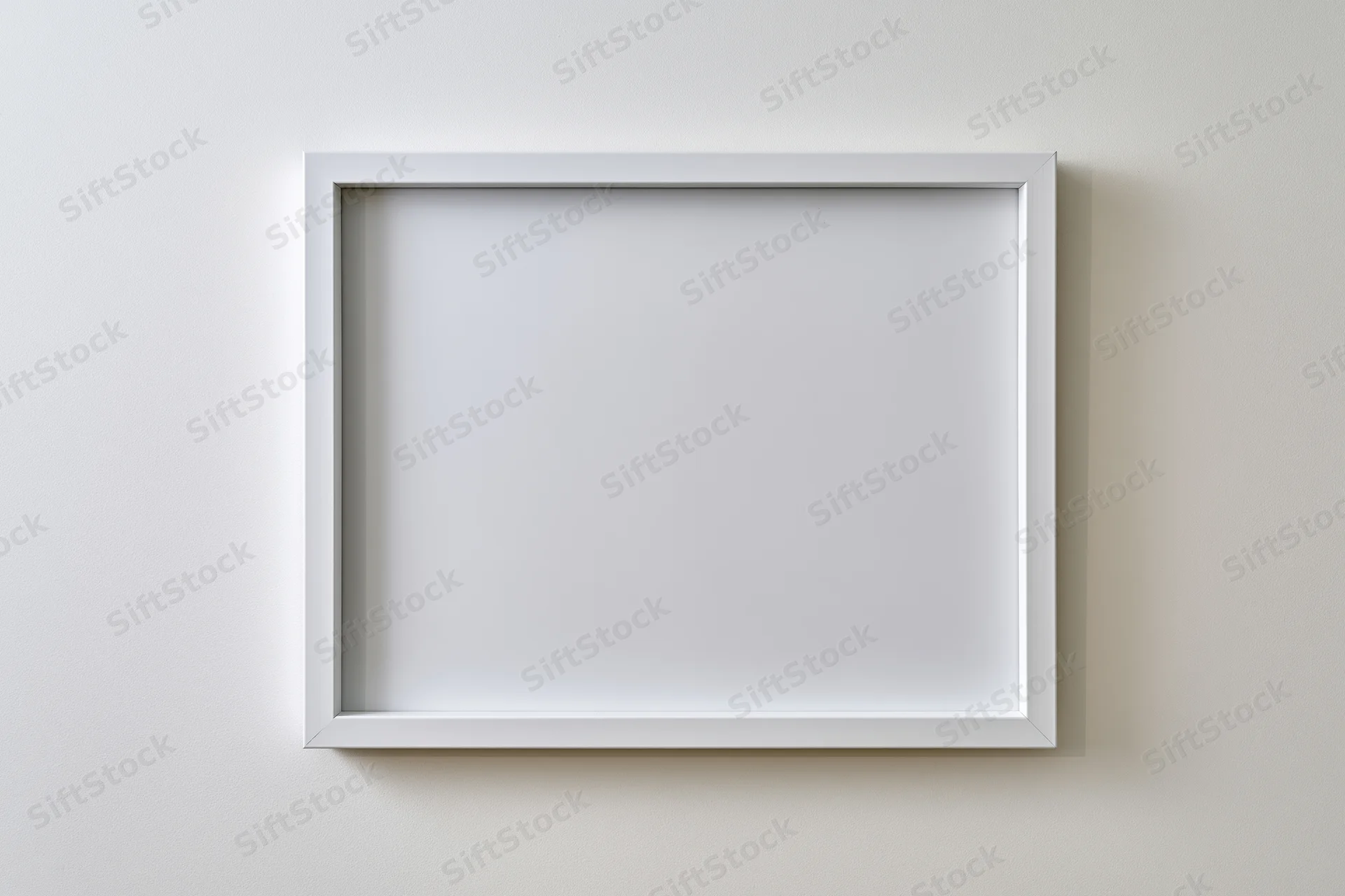 White empty picture frame mounted on off-white wall