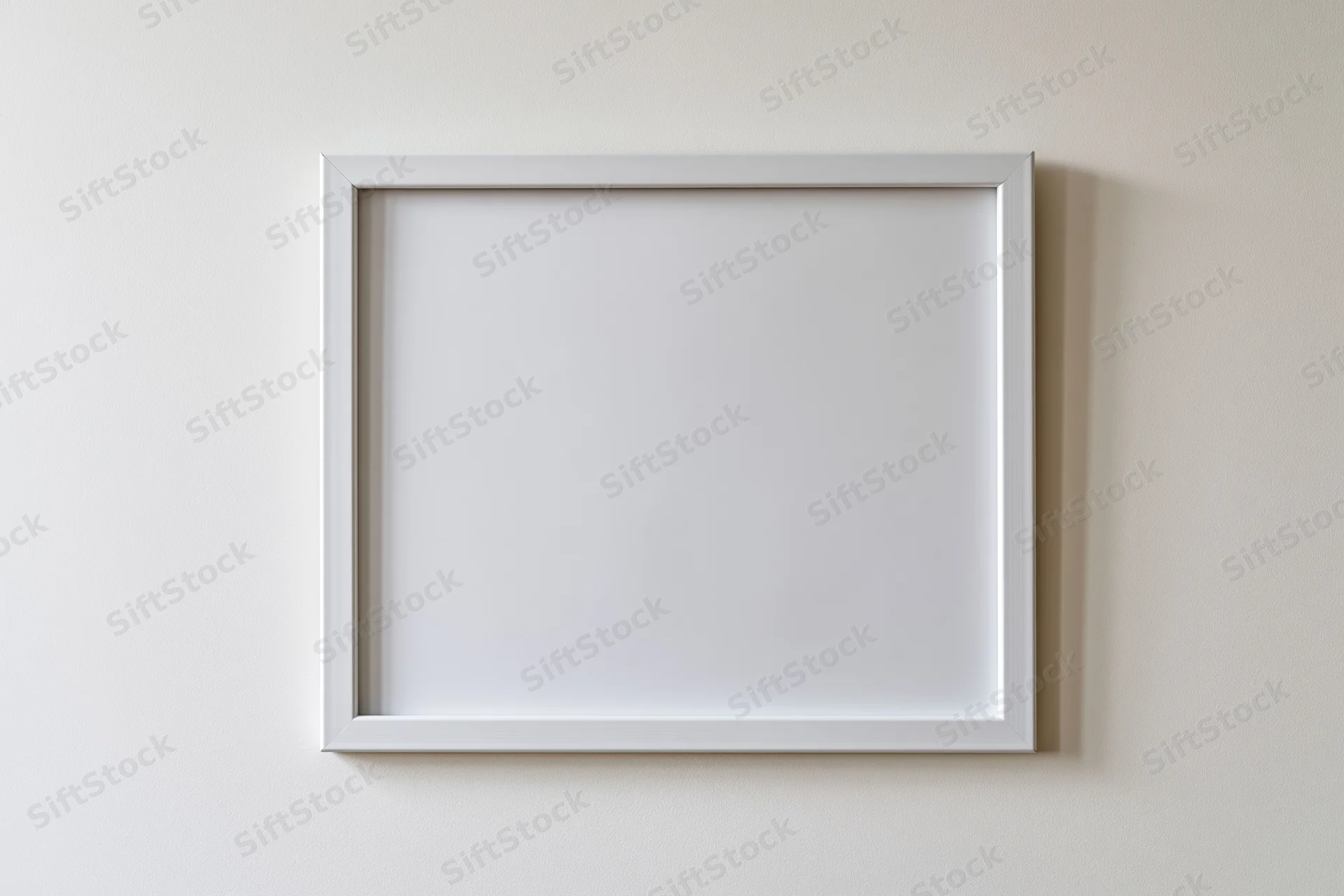 White empty picture frame mounted on off-white wall
