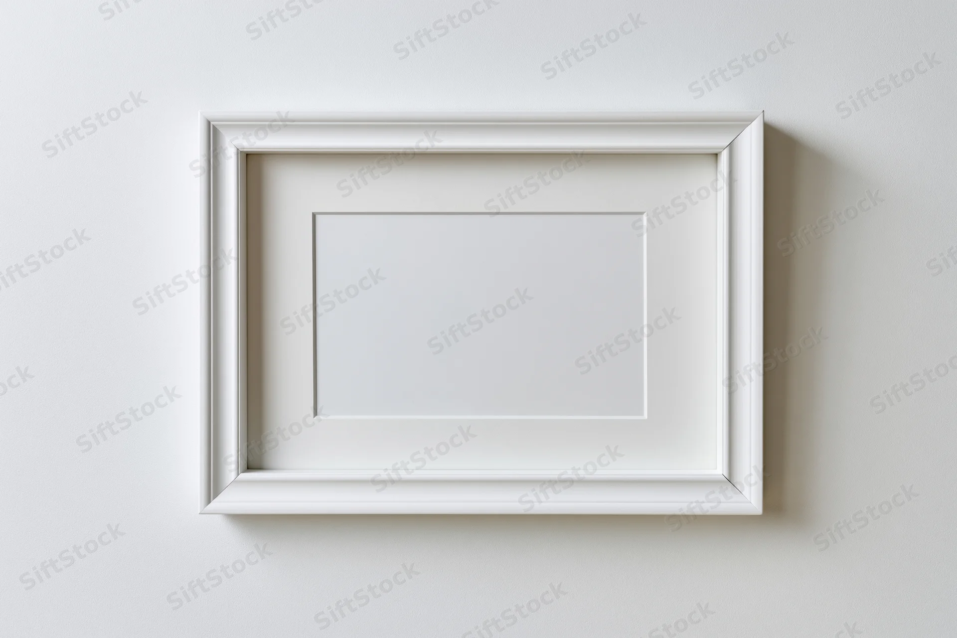 White rectangular picture frame with thin molded border hanging on a plain wall