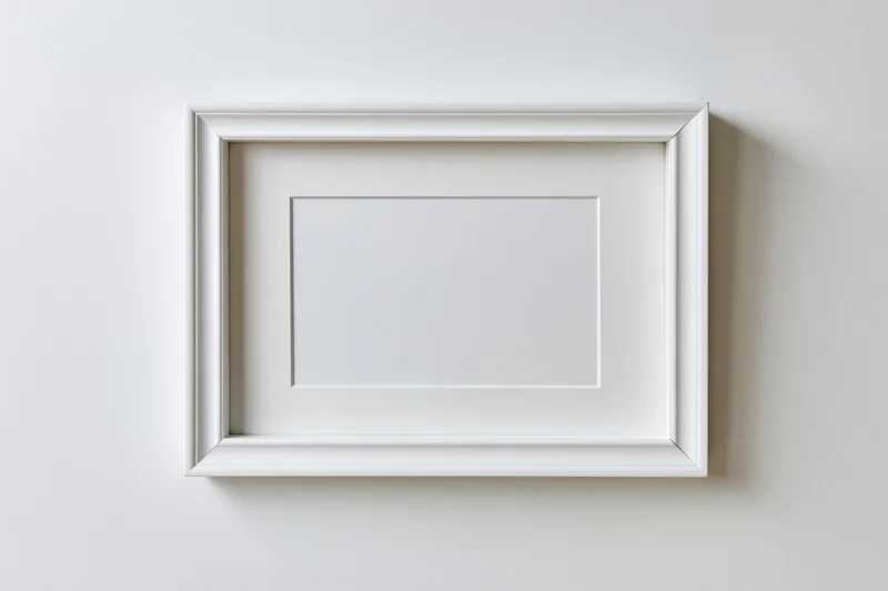 White rectangular picture frame with thin molded border hanging on a plain wall