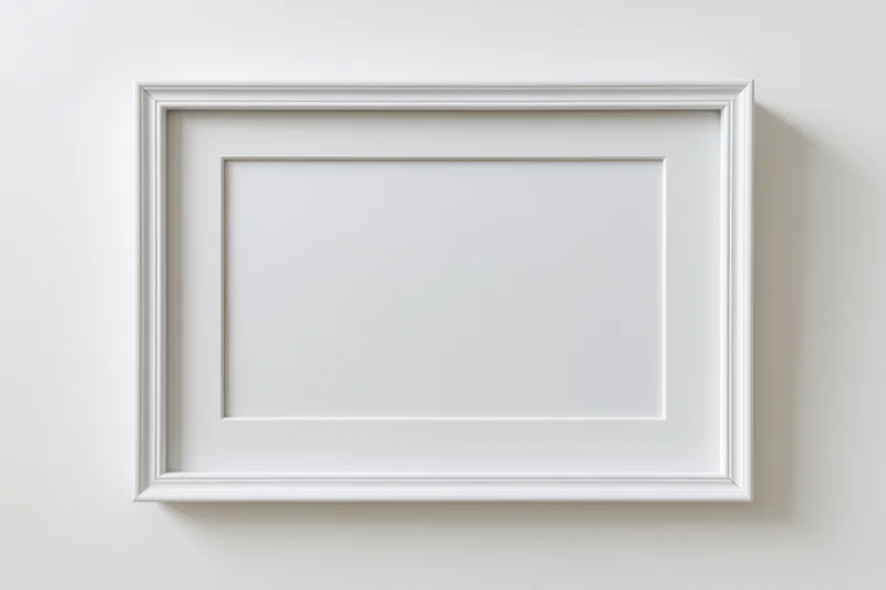 White rectangular picture frame mounted on a plain wall with empty space for artwork