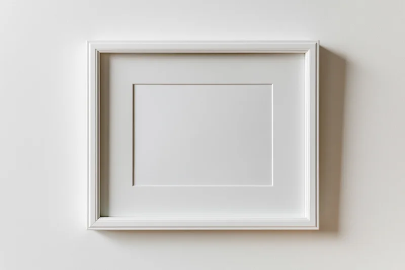 White rectangular picture frame with thin molded border hanging on a plain wall