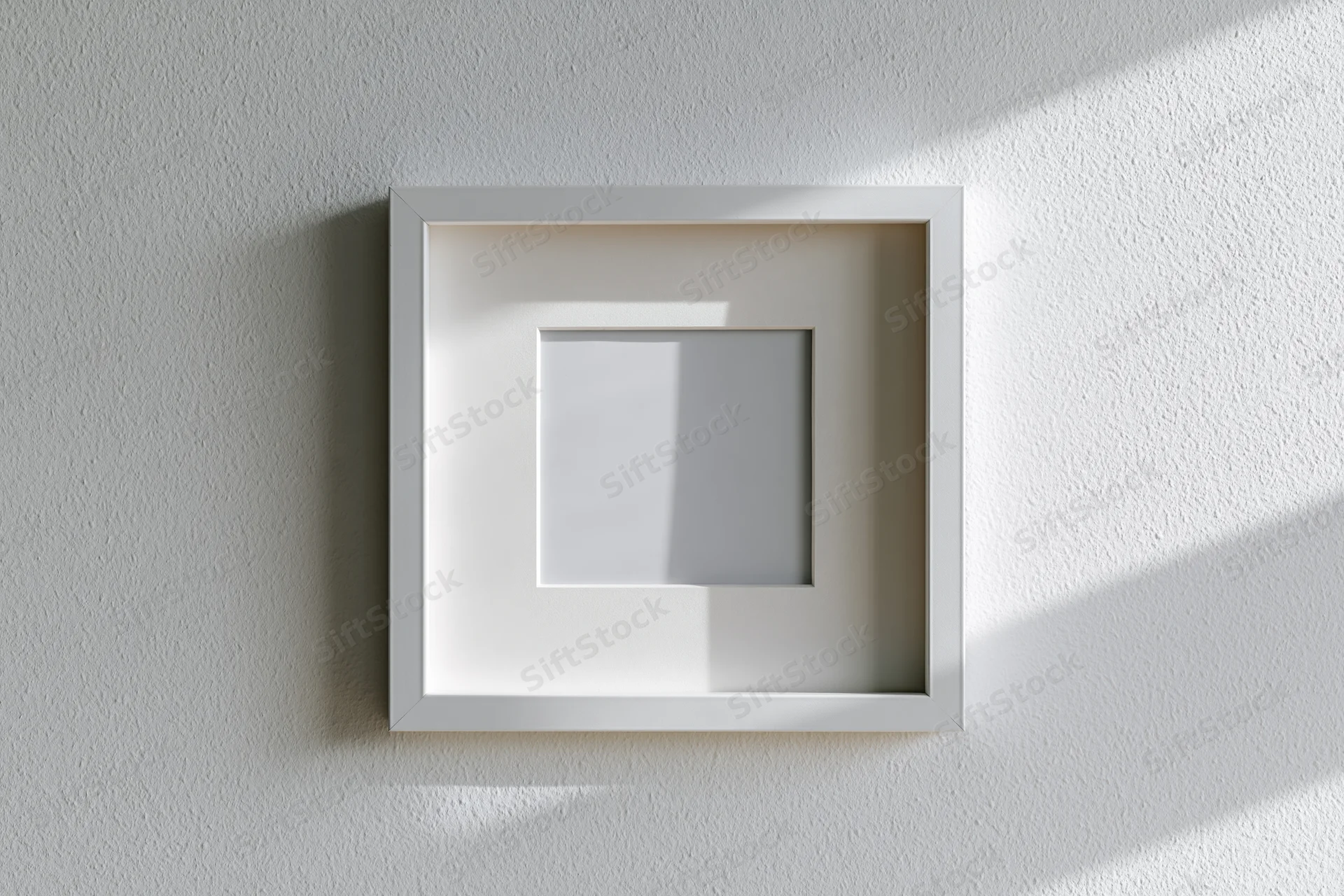 White square picture frame with wide mat hanging on textured wall