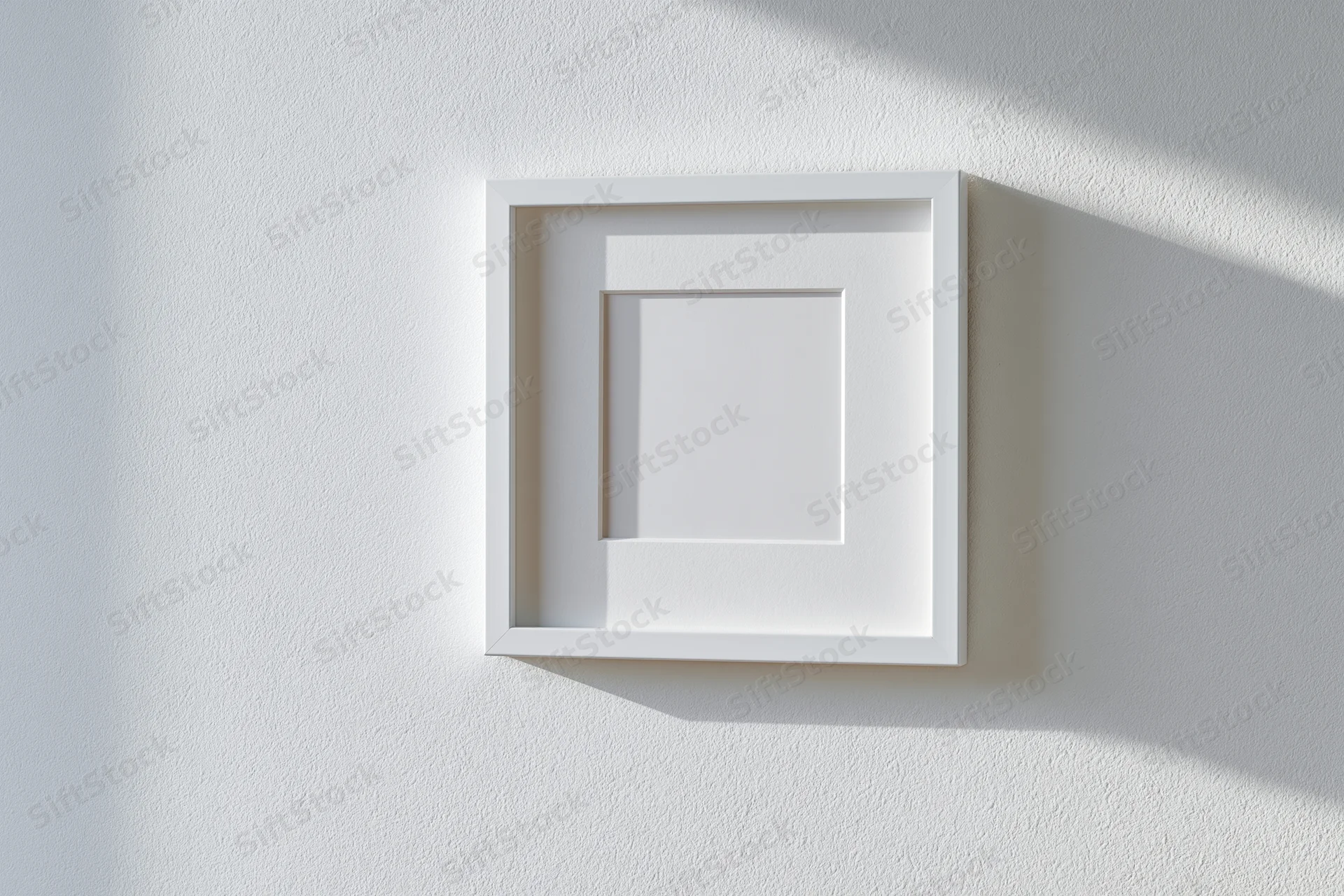 White square picture frame with wide mat hanging on a textured wall