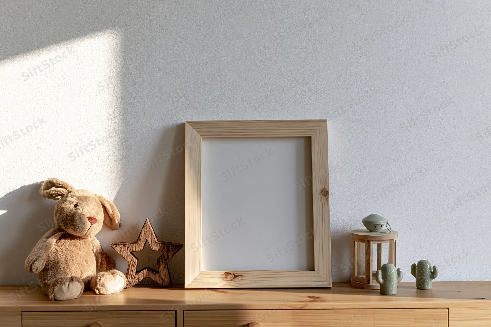 Empty wooden picture frame leaning on a shelf beside a stuffed rabbit and decorative objects