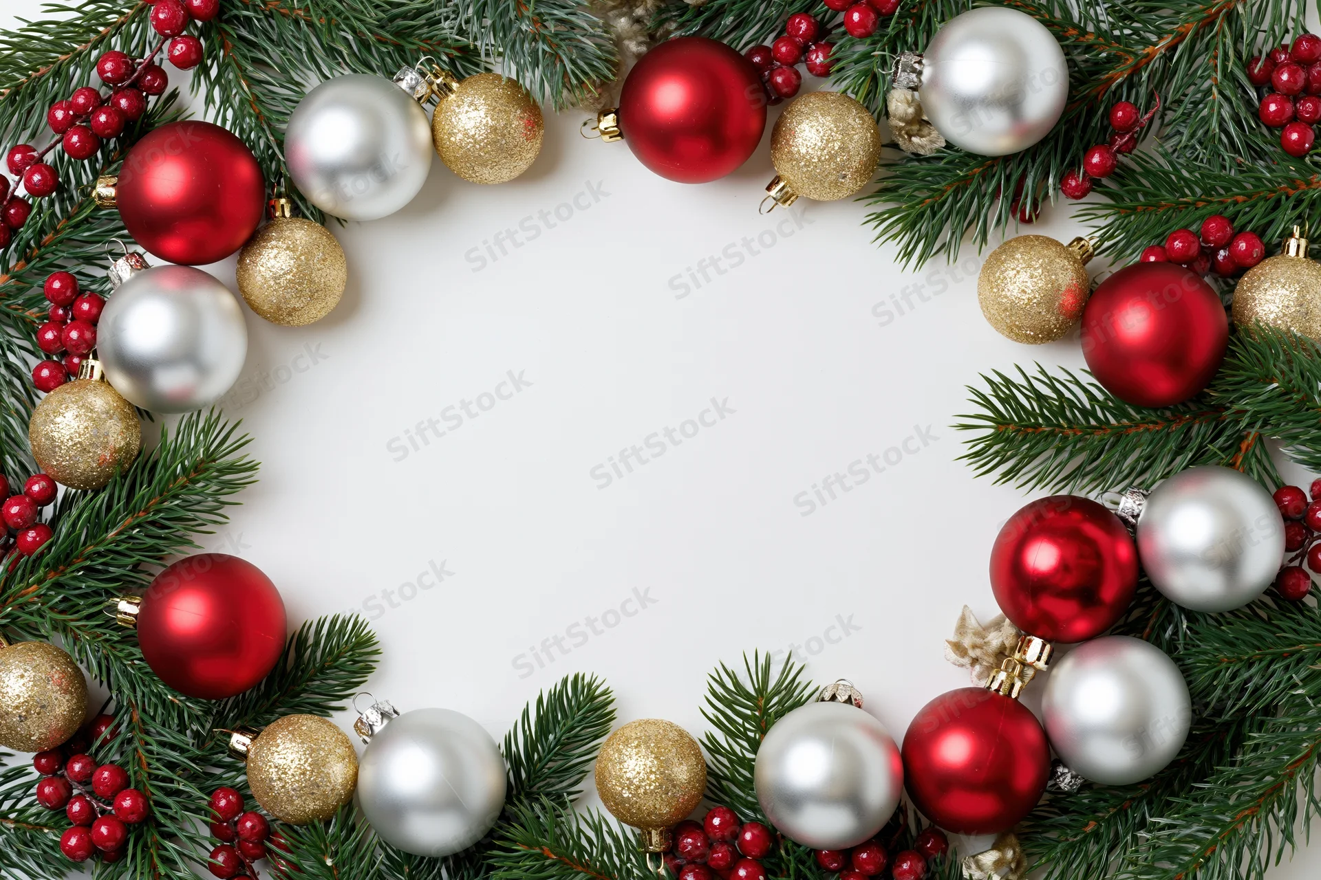 Fir branches and ornaments arranged in a border frame on white background with copyspace