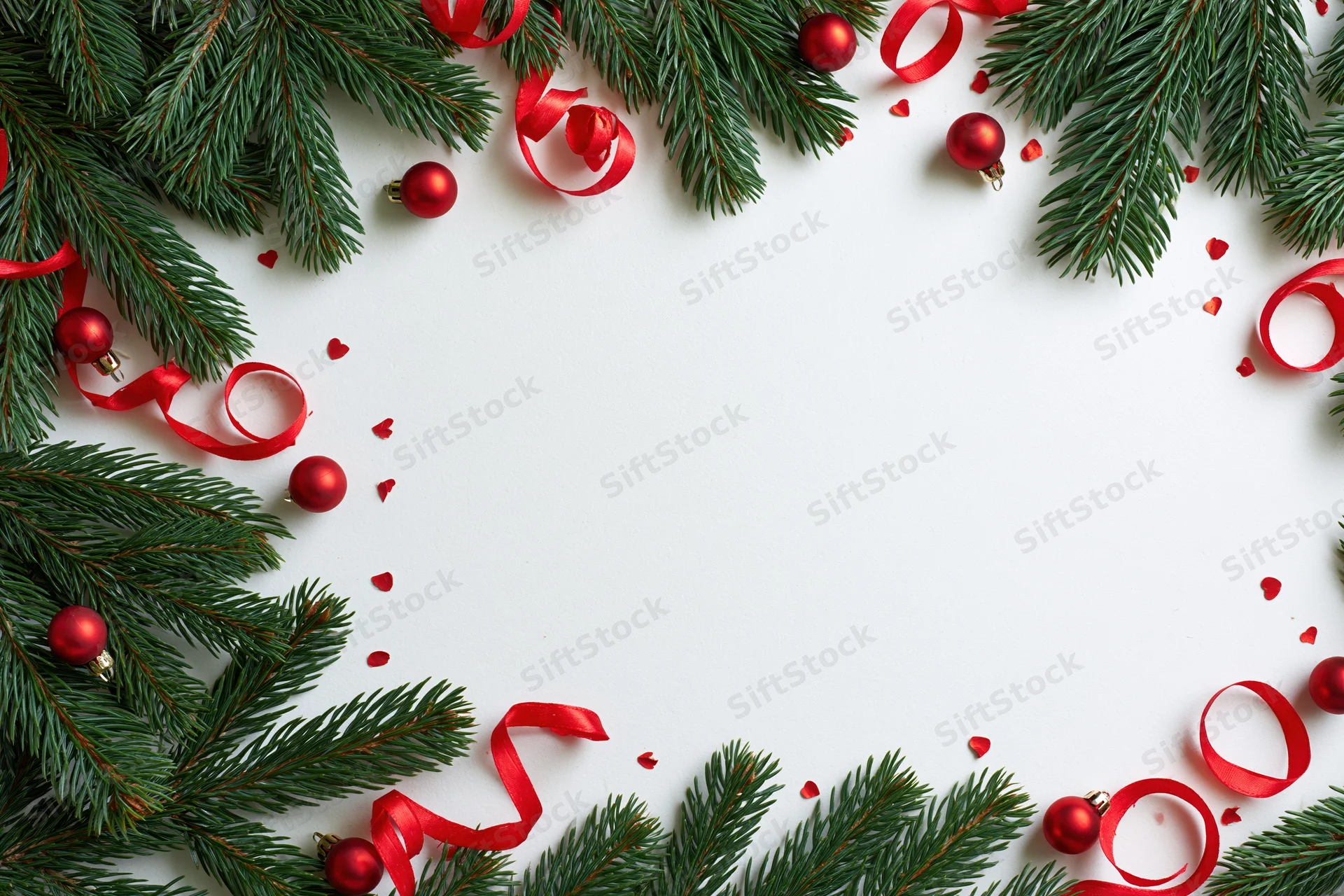 Christmas border frame made of green fir branches and red ornaments on white background with copyspace