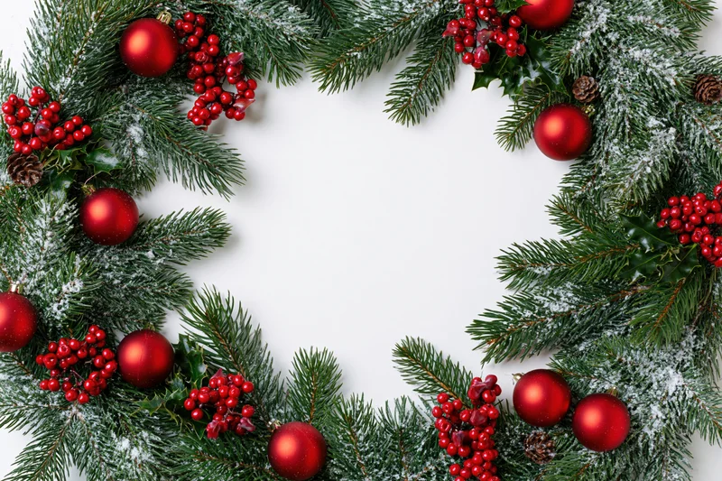 Christmas wreath border made of pine and fir branches with red ornaments and berries on white background