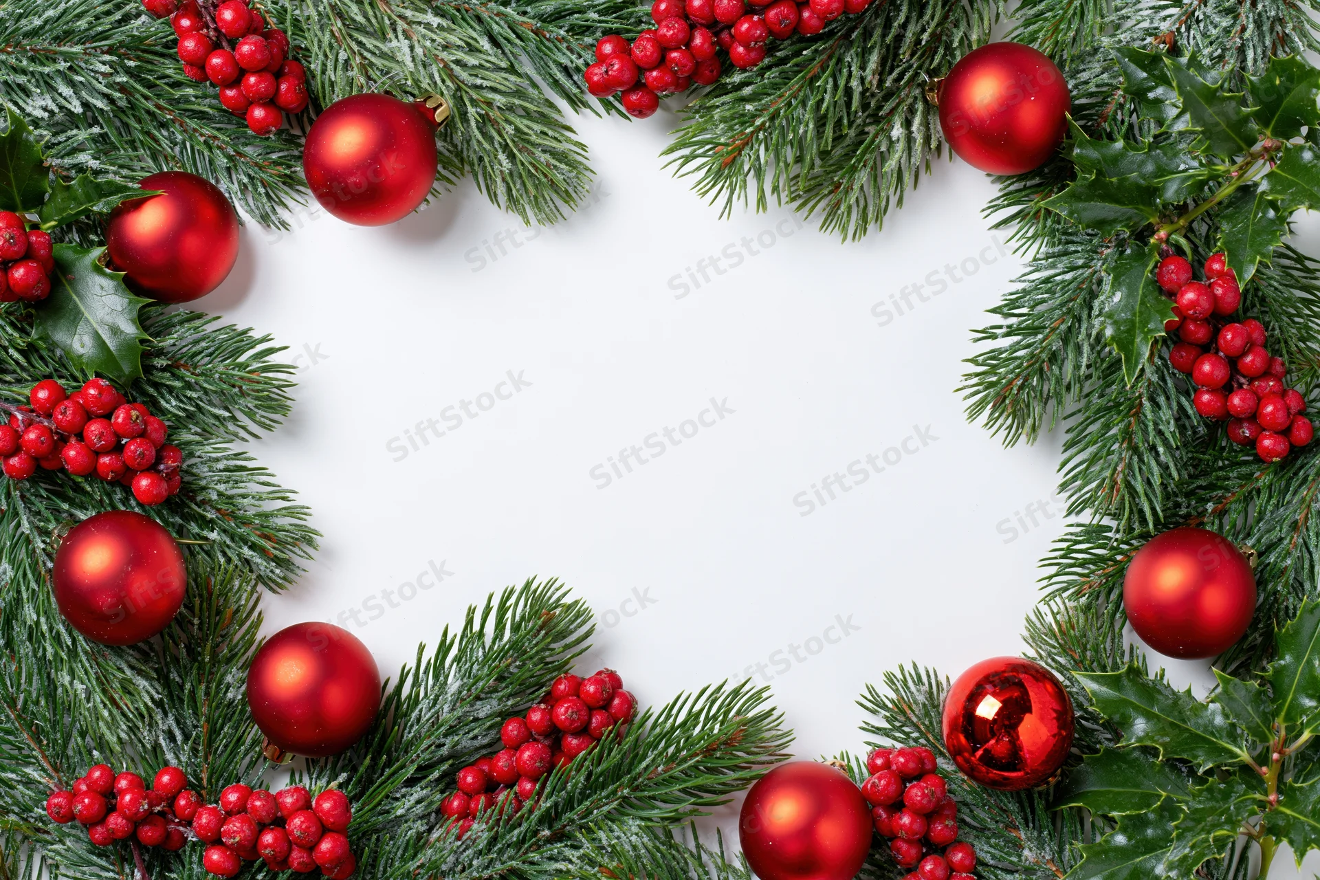Pine branches and red ornaments arranged in a circular frame on white background with copyspace
