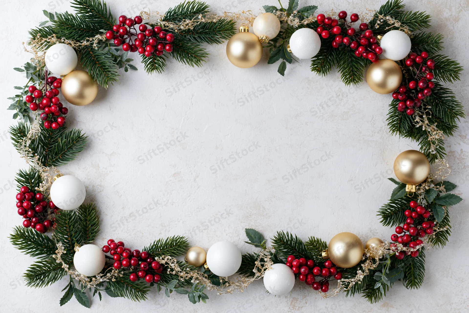 Circular christmas wreath made of pine branches, red berries, and gold and white ornaments arranged on white surface with copyspace
