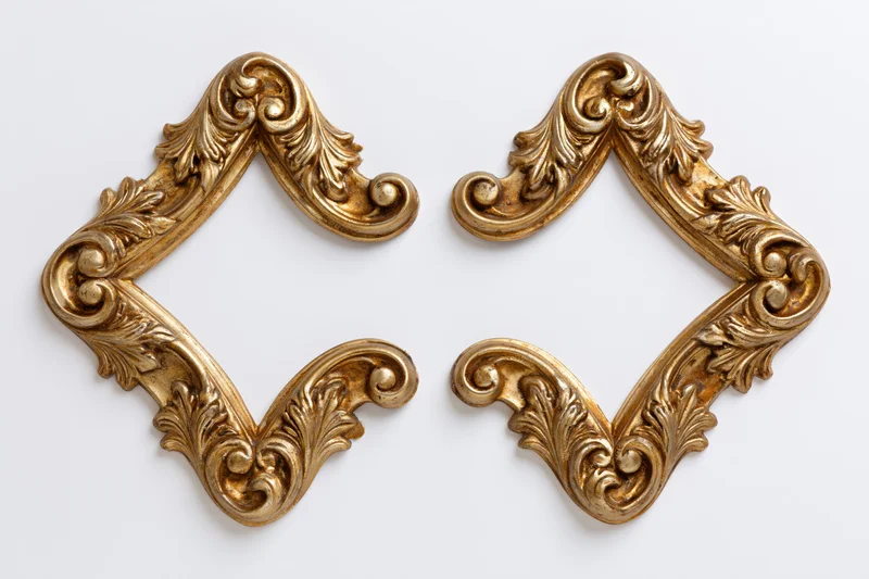 Two ornate gilded baroque corner pieces arranged symmetrically on white background