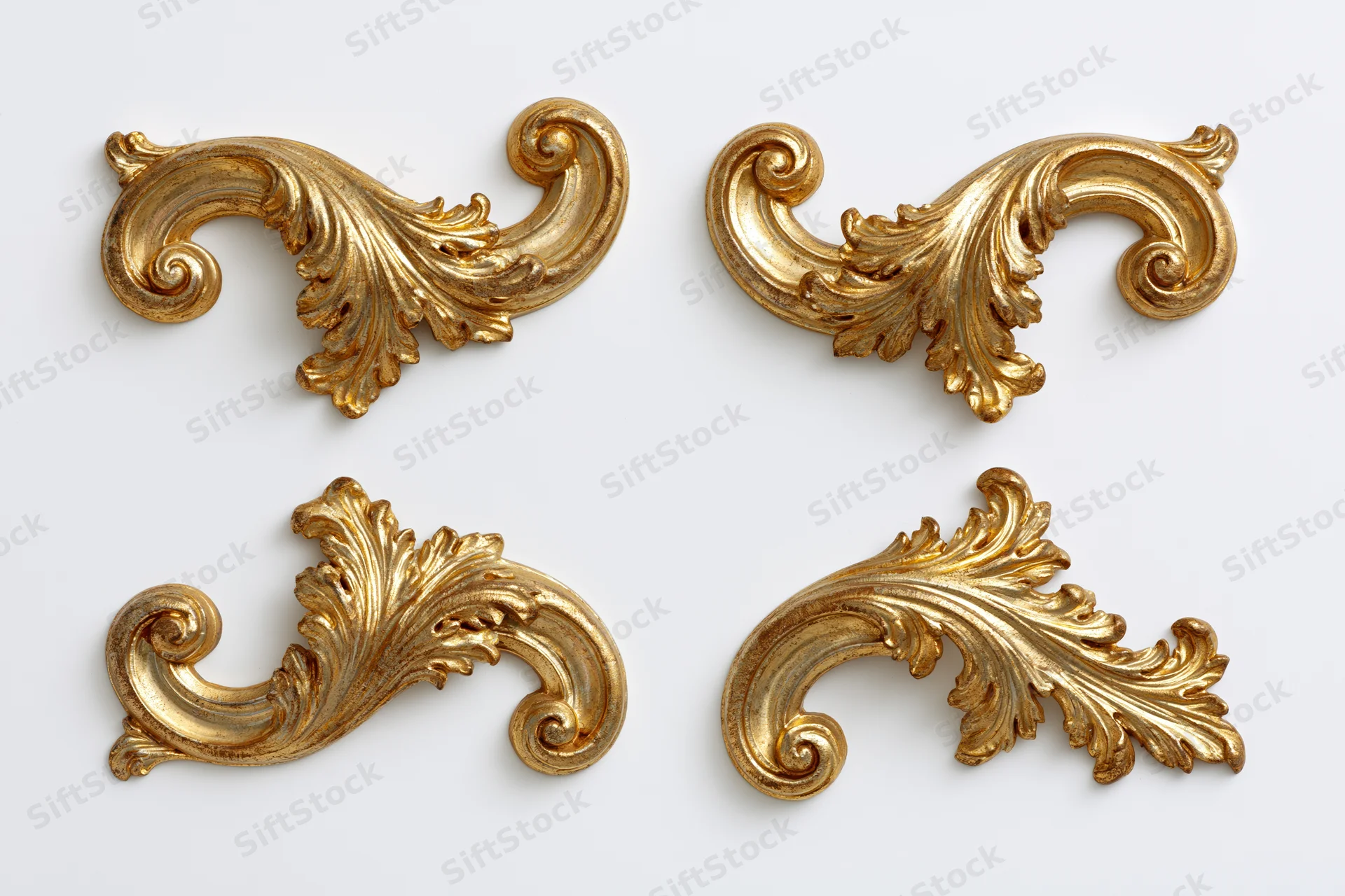 Four ornate gilded baroque corner pieces arranged symmetrically on white background