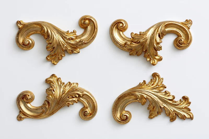 Four ornate gilded baroque corner pieces arranged symmetrically on white background