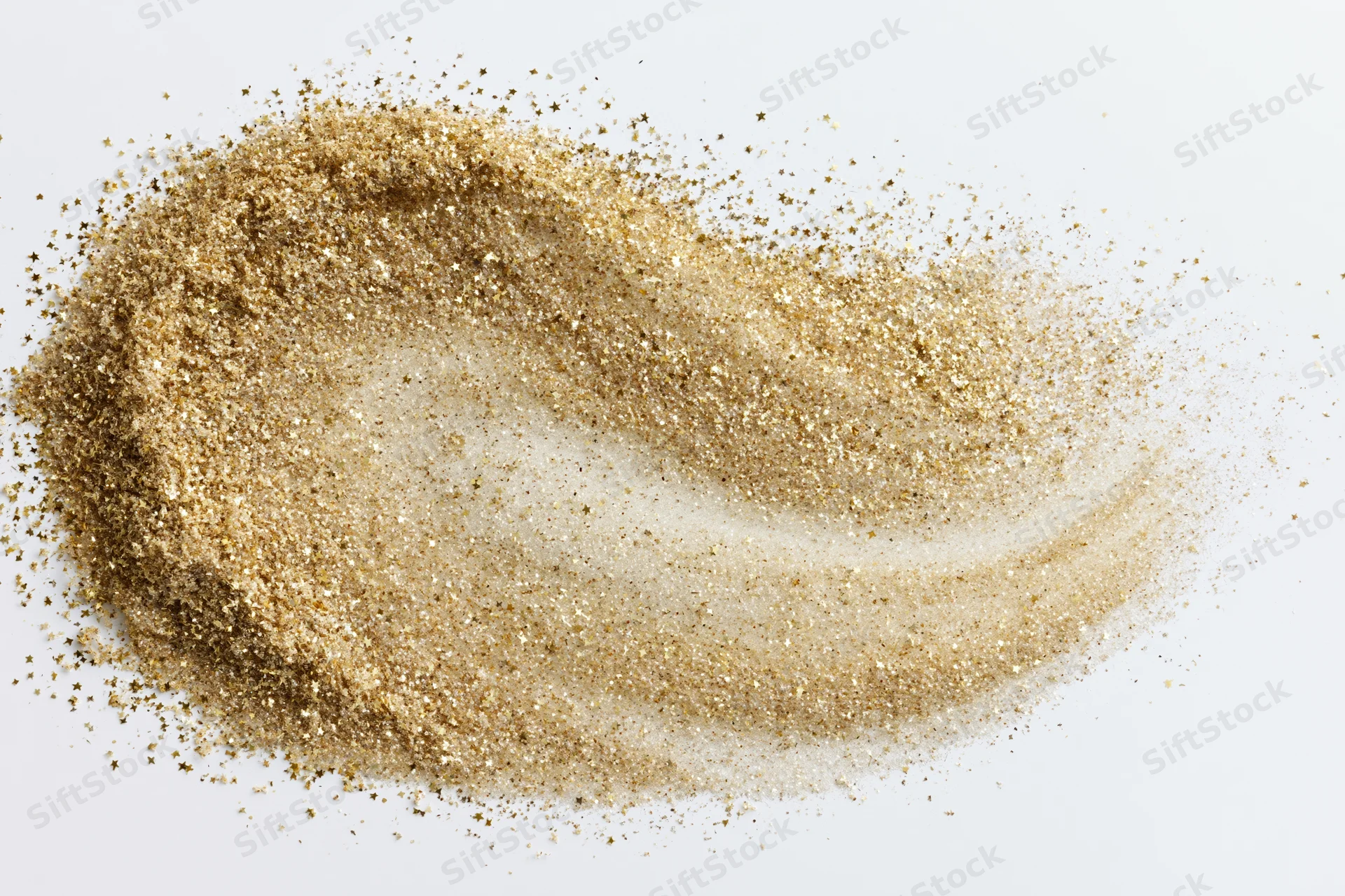 Gold glitter dust scattered in a swirling pattern on white background