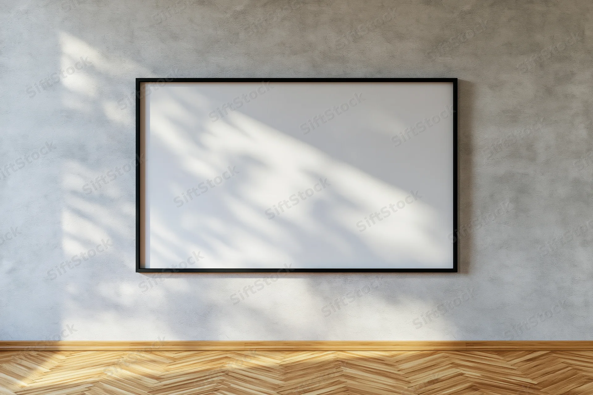 Black-framed blank canvas hanging on a concrete wall with sunlight casting shadows on a wooden parquet floor