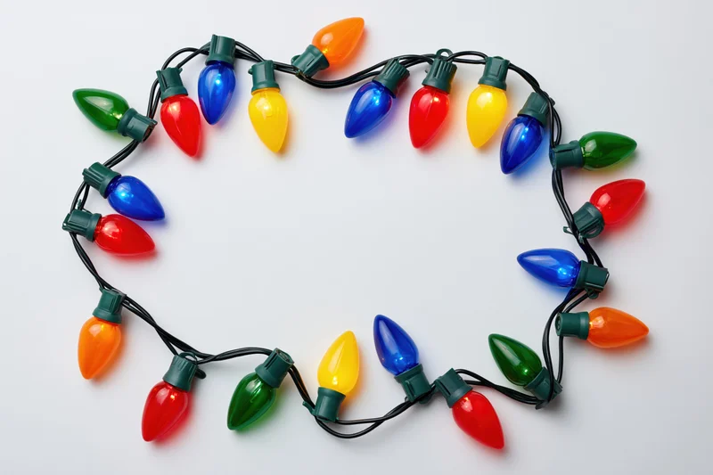 Multicolored christmas string lights arranged in a circular frame on white background