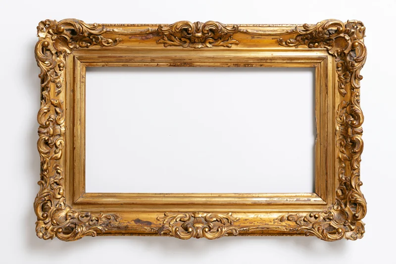 Ornate antique gold picture frame with intricate carvings photographed flat against a white background