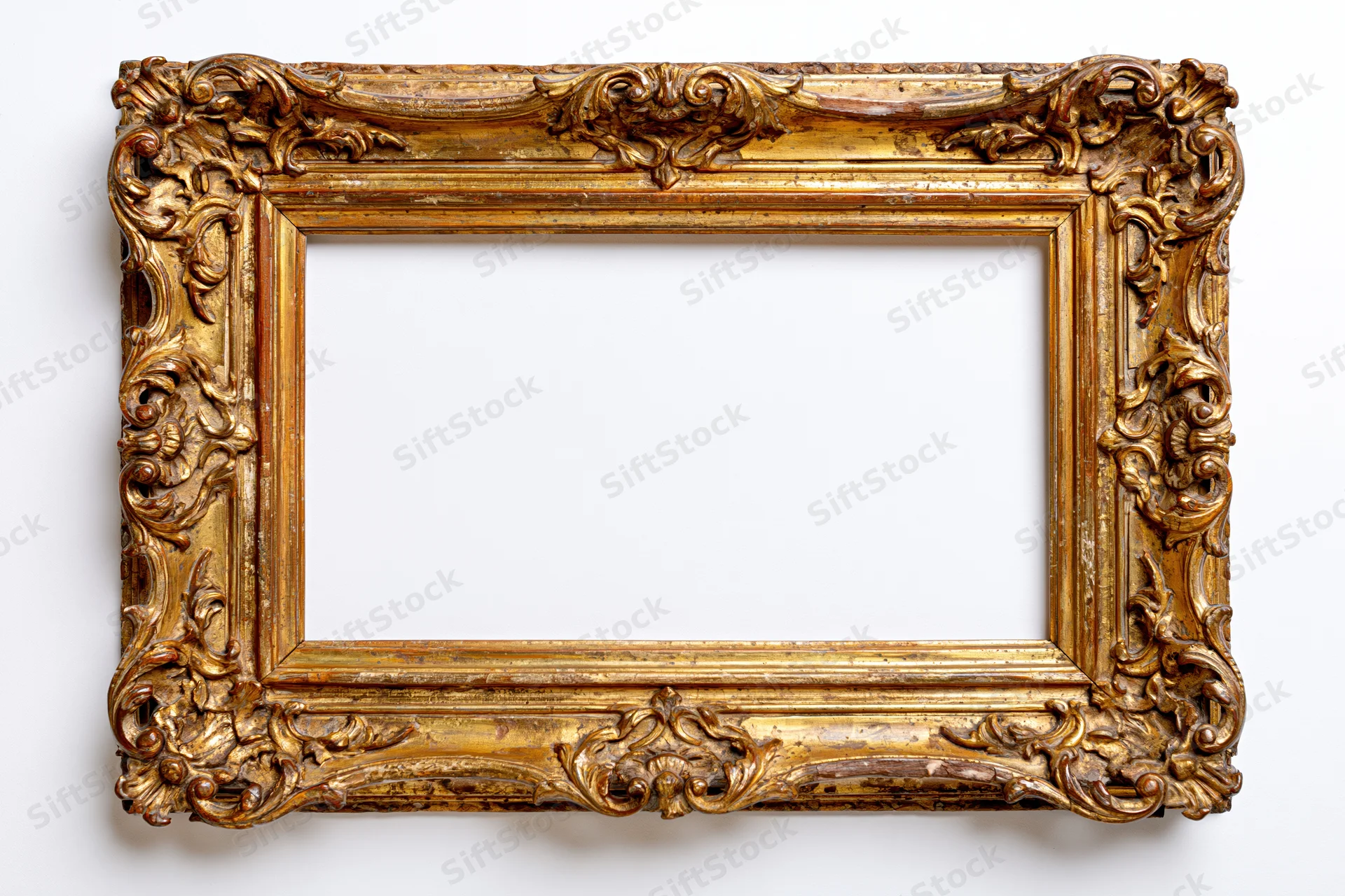 Ornate antique gold picture frame with baroque carvings photographed flat against white background