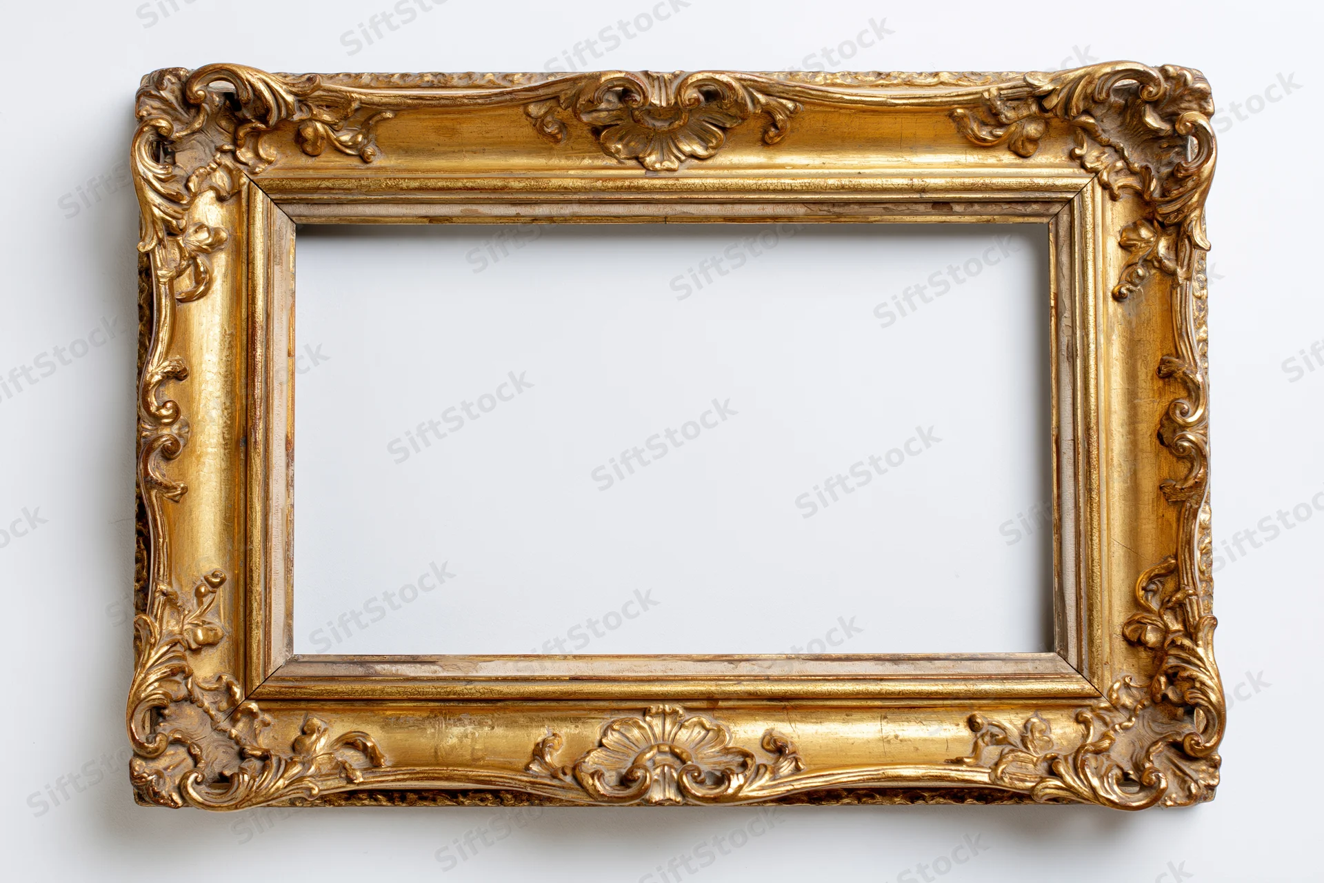 Ornate antique gold picture frame with baroque carved floral details on white background