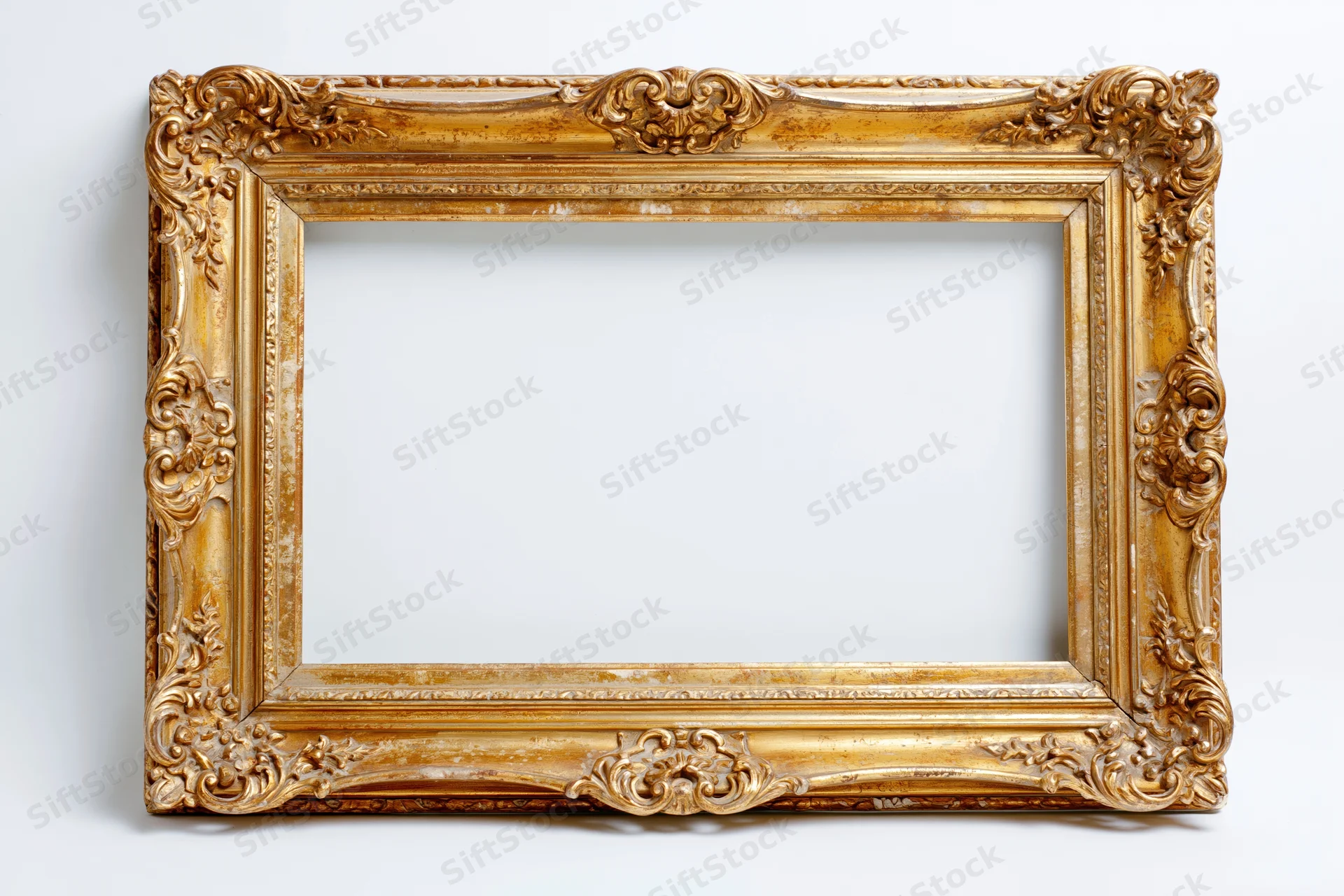 Ornate antique gold picture frame with baroque carved floral details on white background