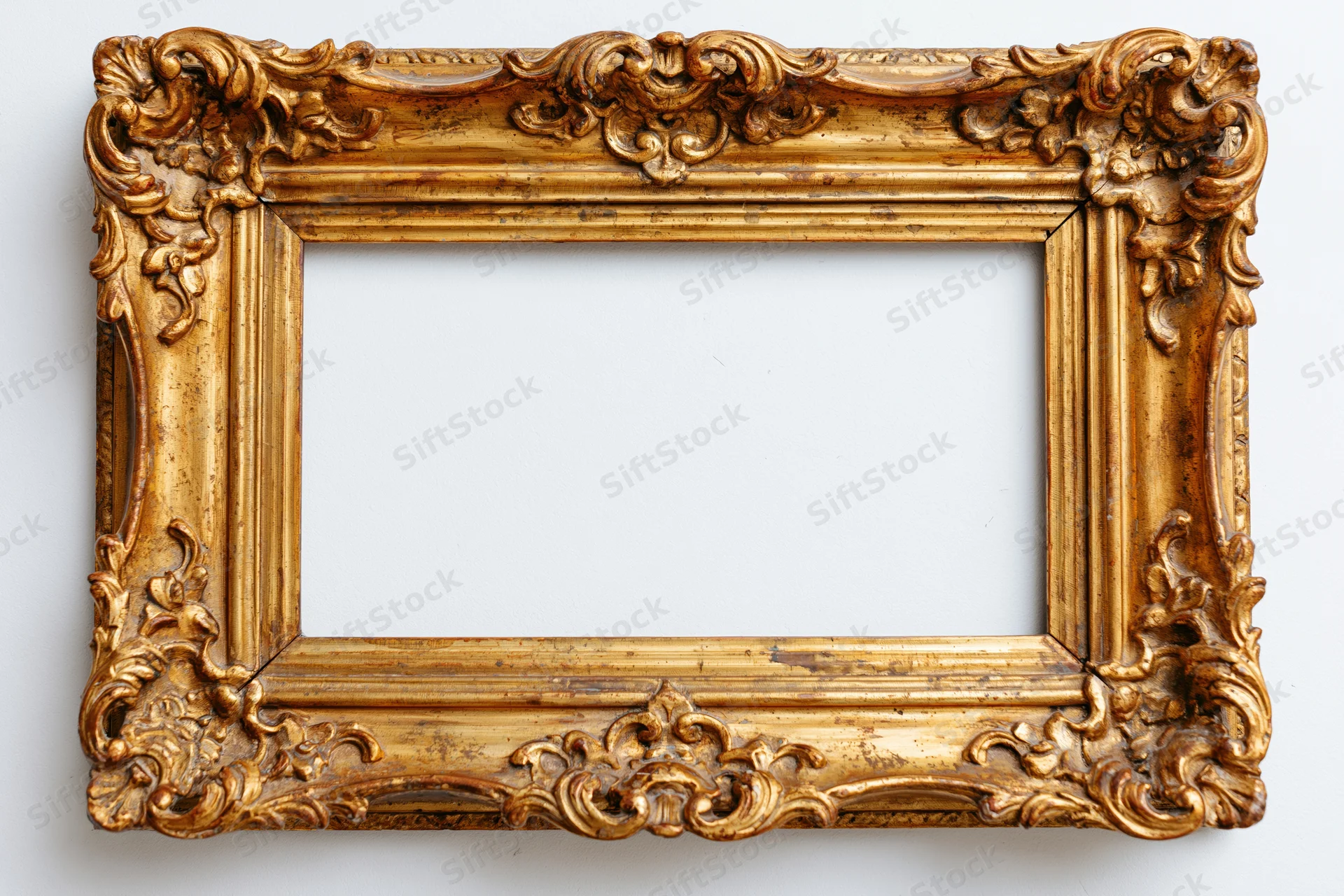 Ornate antique gold picture frame with baroque carved floral details on white background