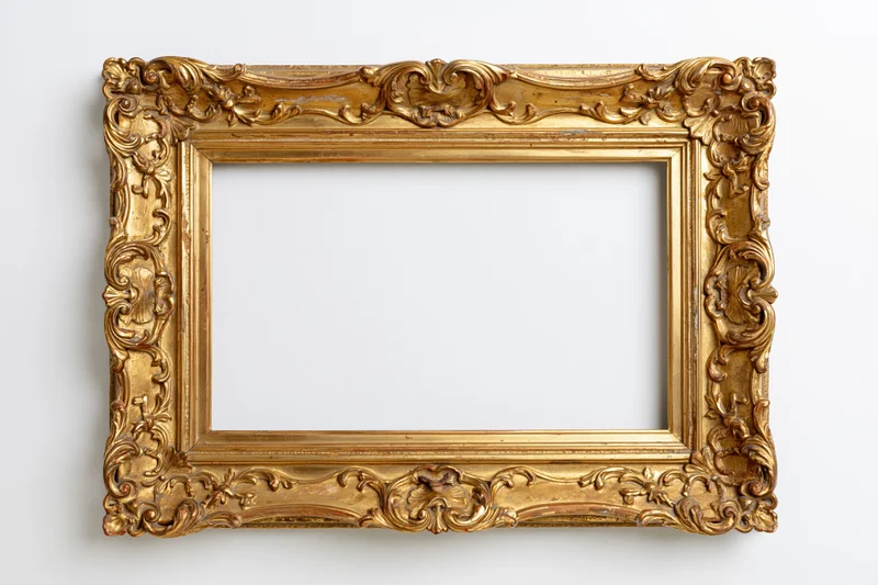 Ornate antique gold picture frame with baroque carved scrollwork hanging on white wall