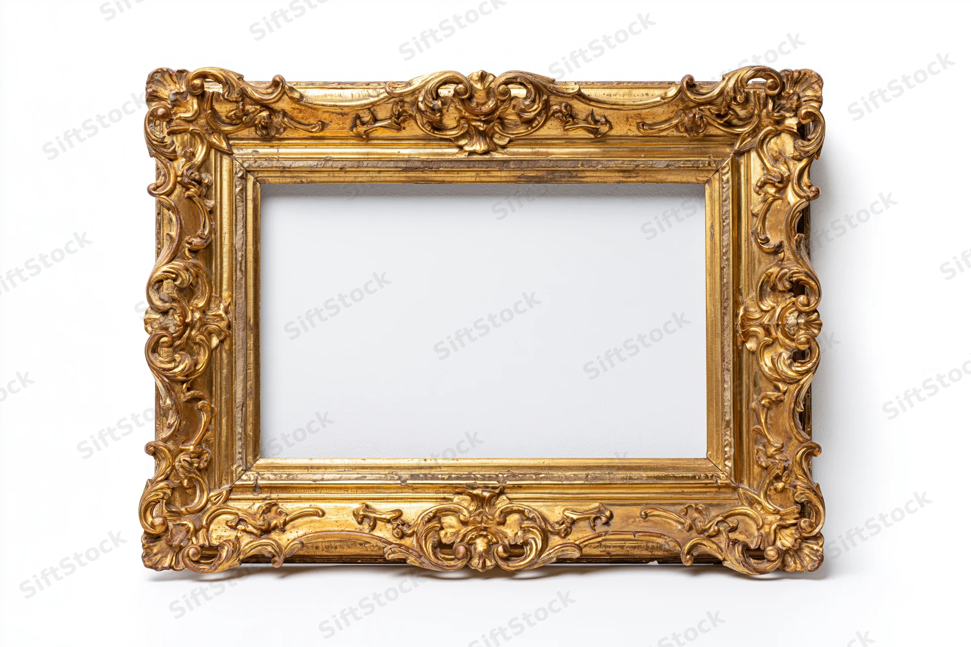 Ornate antique gold picture frame with baroque carved scrollwork isolated on white background