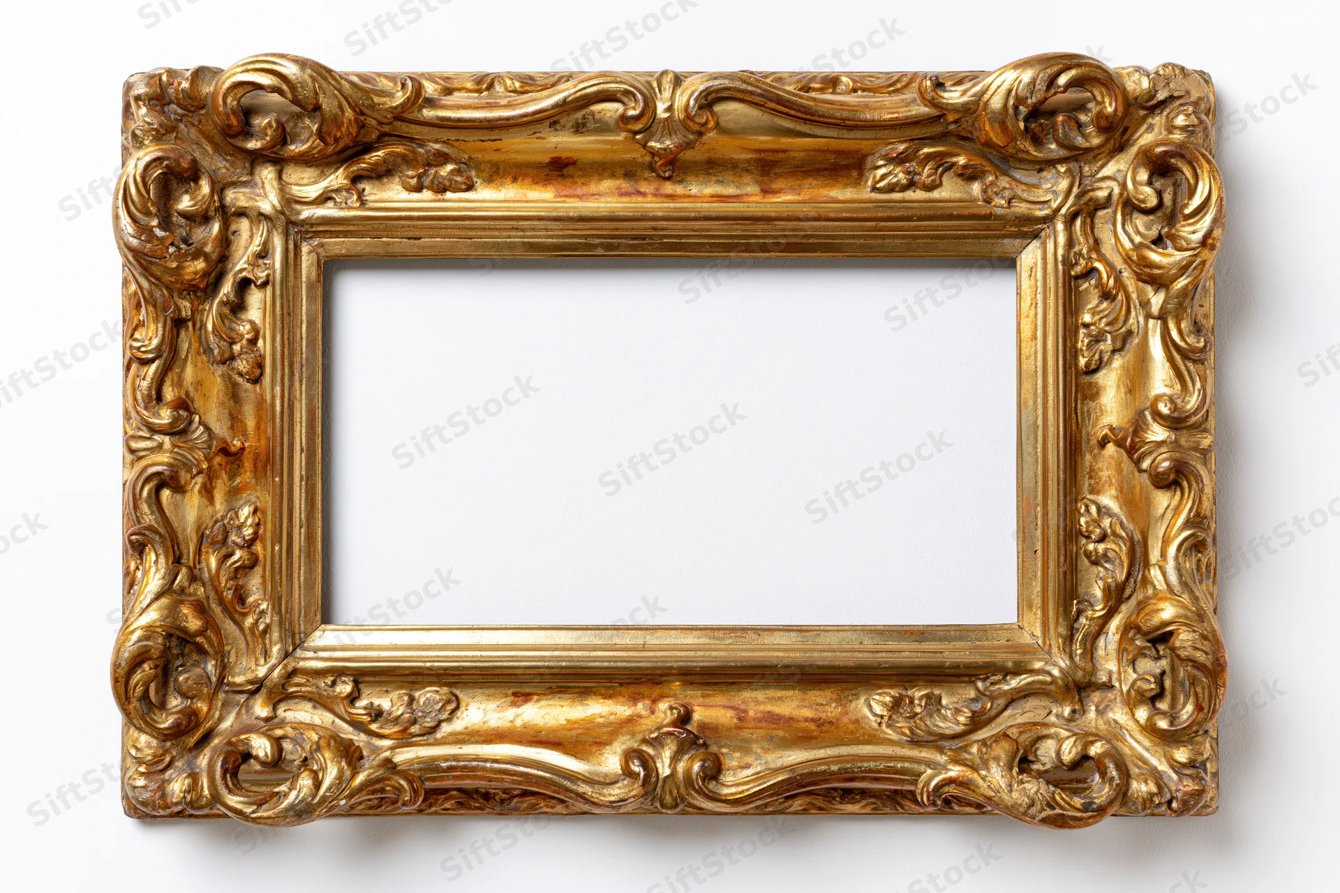 Ornate antique gold picture frame with baroque carved scrollwork, empty and isolated on white background