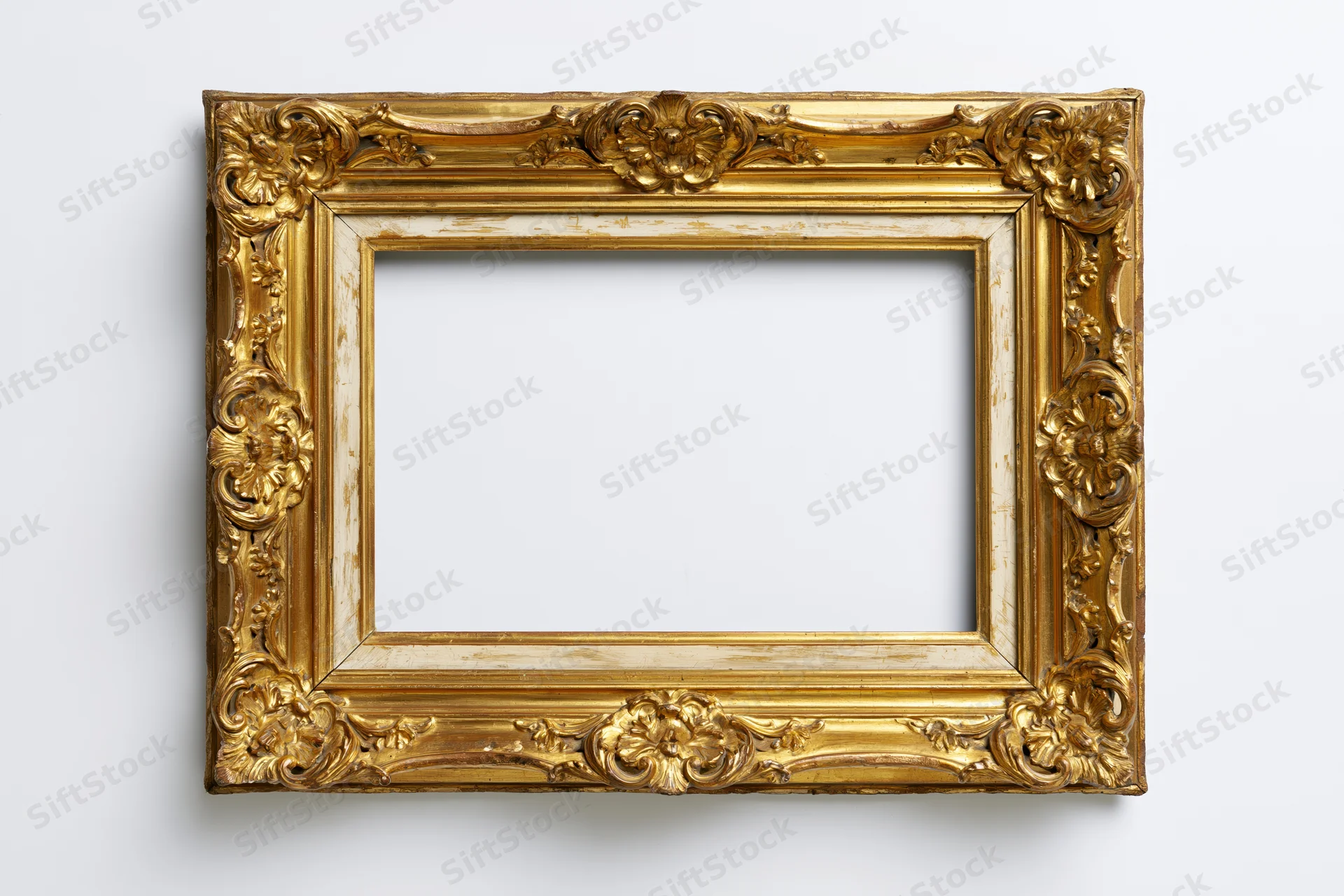 Ornate antique gold picture frame with baroque floral relief on white background