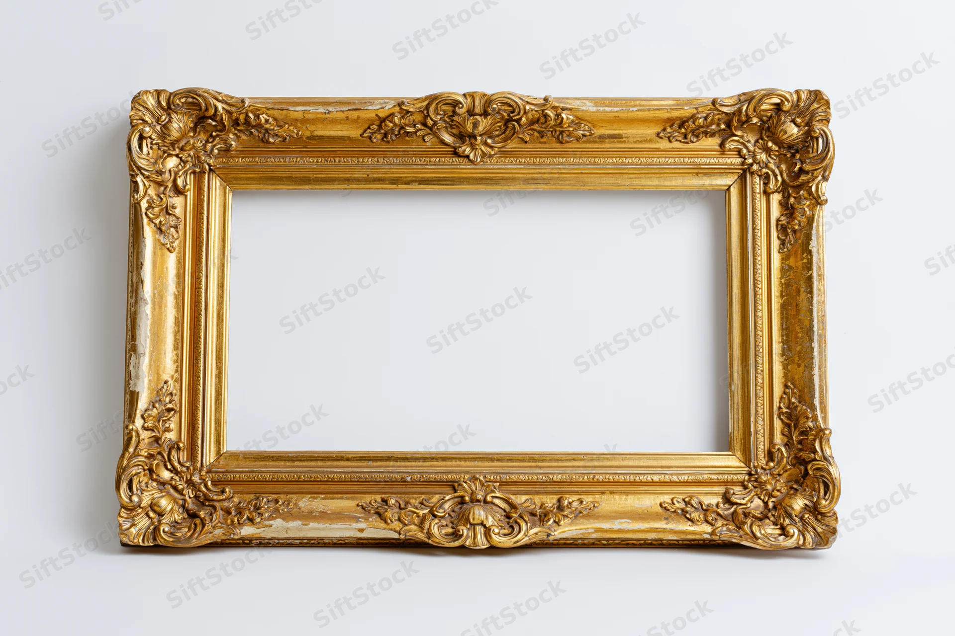 Ornate antique gold picture frame with baroque floral relief on white background