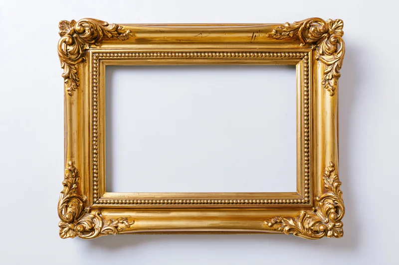 Ornate gold picture frame with empty white interior hanging on a wall