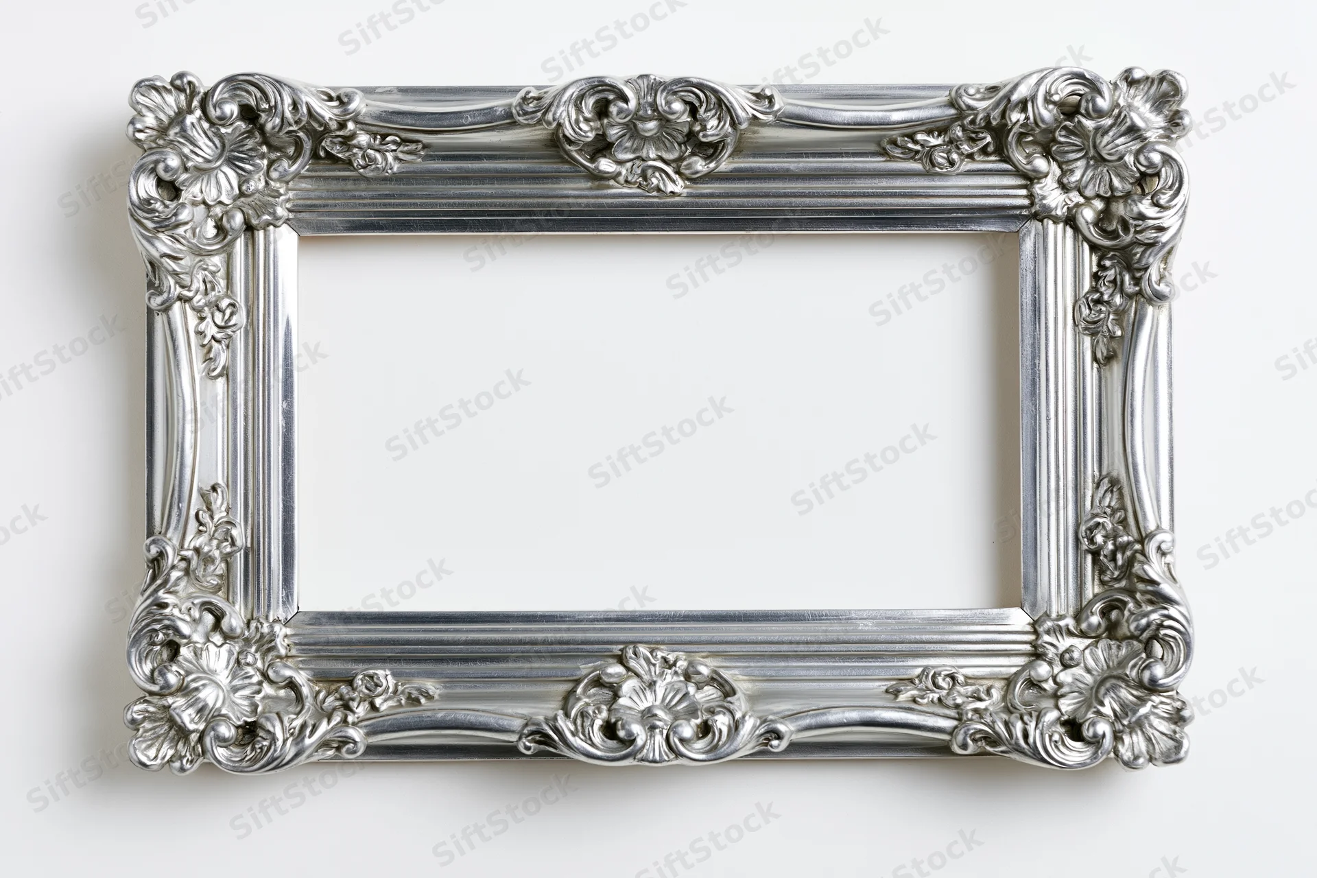 Ornate silver picture frame with baroque floral details on white background