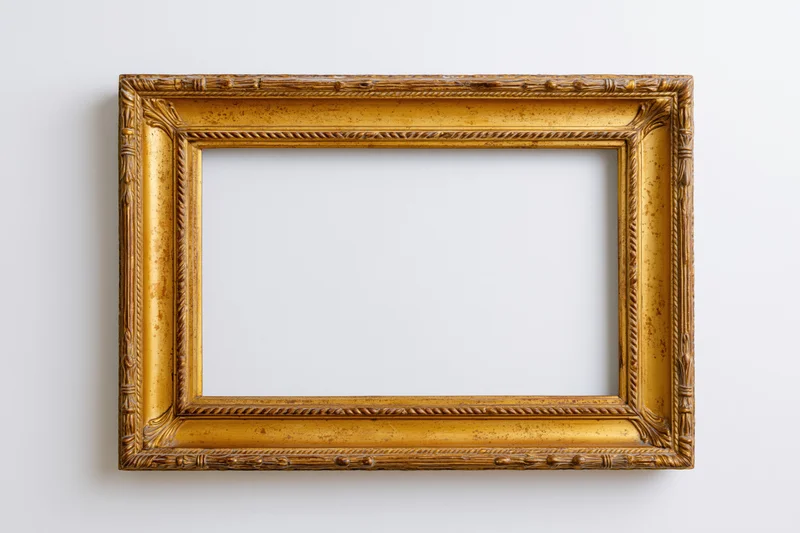 Ornate gilded wooden picture frame hanging on a white wall with empty center for display