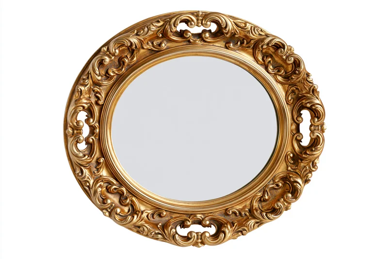 Ornate oval gilt mirror with baroque scrollwork frame isolated on white