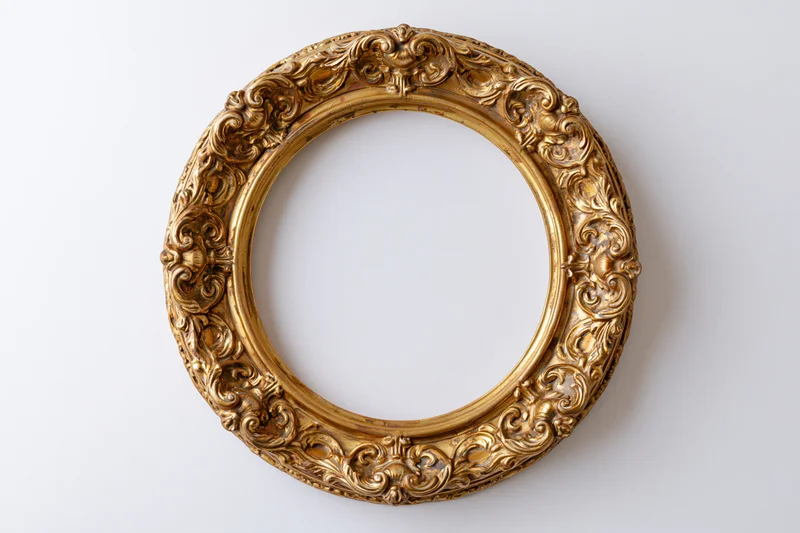 Ornate oval gilt frame with baroque scrollwork on white background