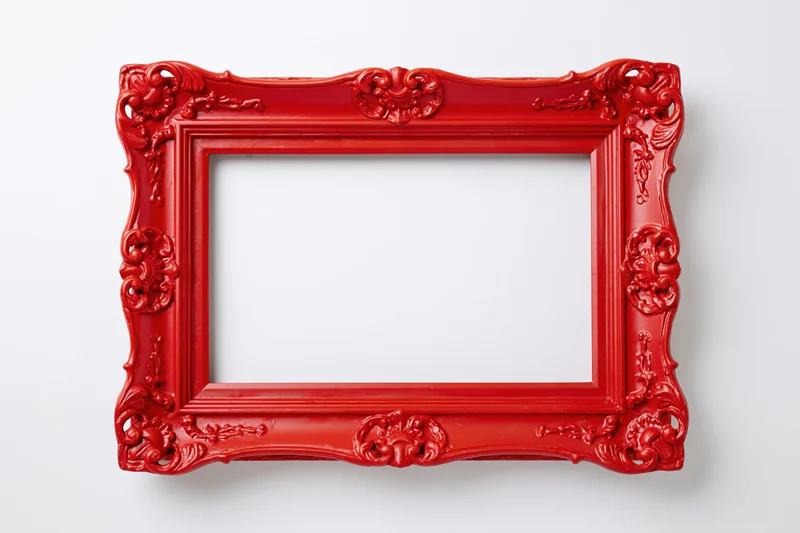 Ornate red vintage picture frame with intricate carvings on white background
