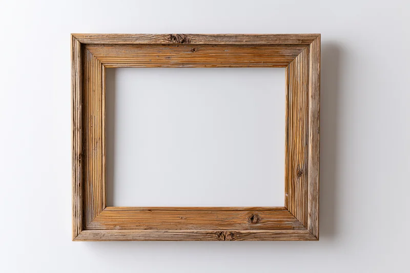 Rustic wooden picture frame with empty white center hanging on a plain wall