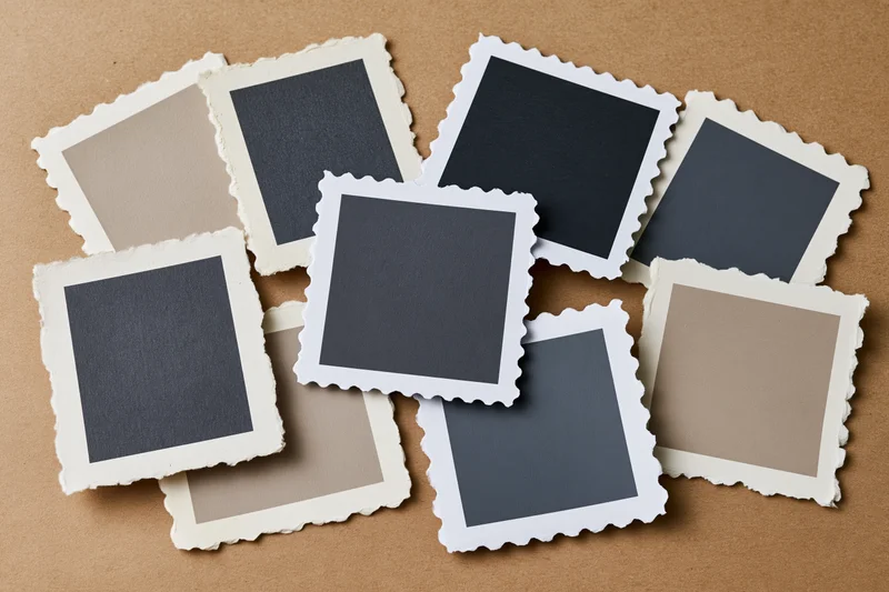 Vintage blank photo prints with deckle edges arranged on brown paper surface