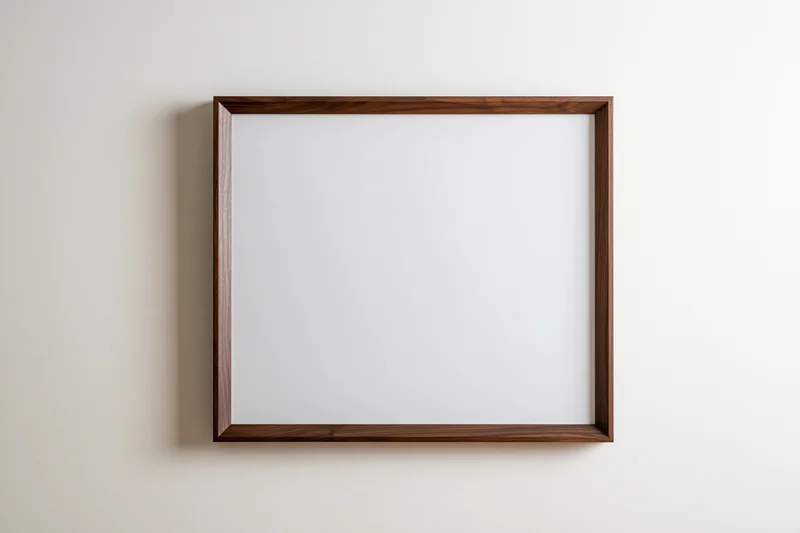 Dark walnut wood picture frame with blank white interior hanging on a light wall