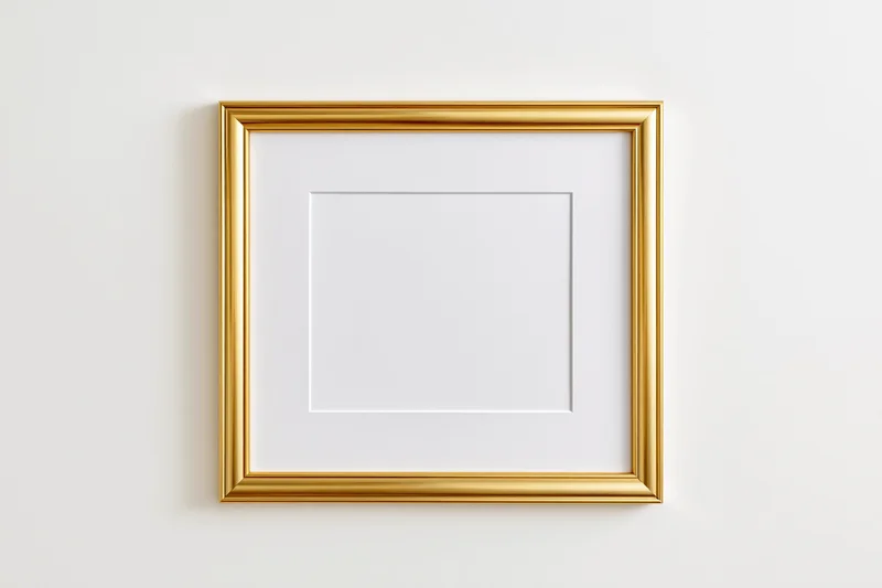 Gold picture frame with white mat hanging on white wall