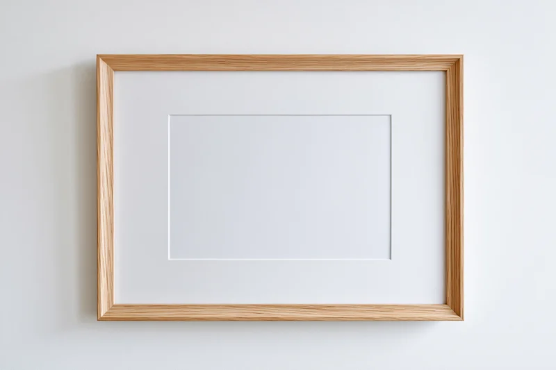 Light oak wooden picture frame with white mat board hanging on a white wall