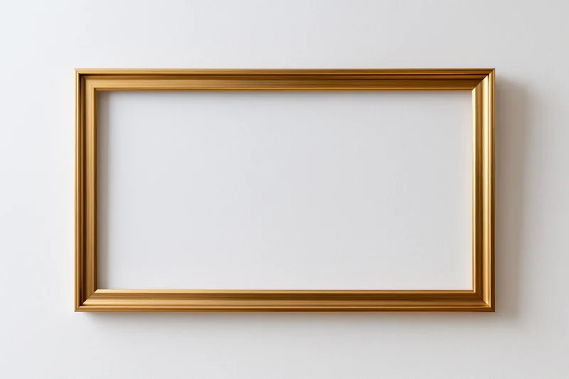 Gold rectangular picture frame hanging on white wall