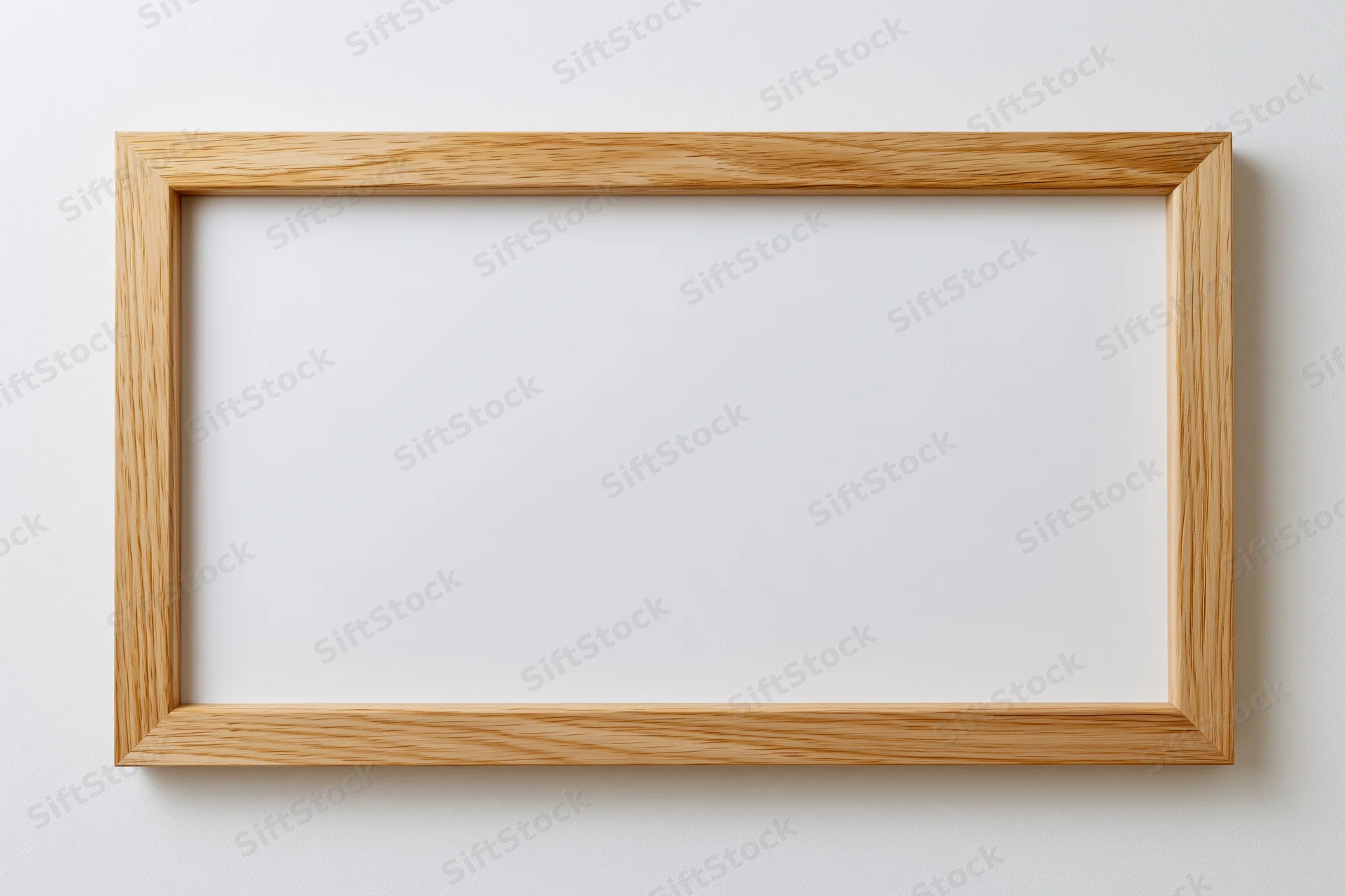 Wooden picture frame hanging on a white wall with empty interior