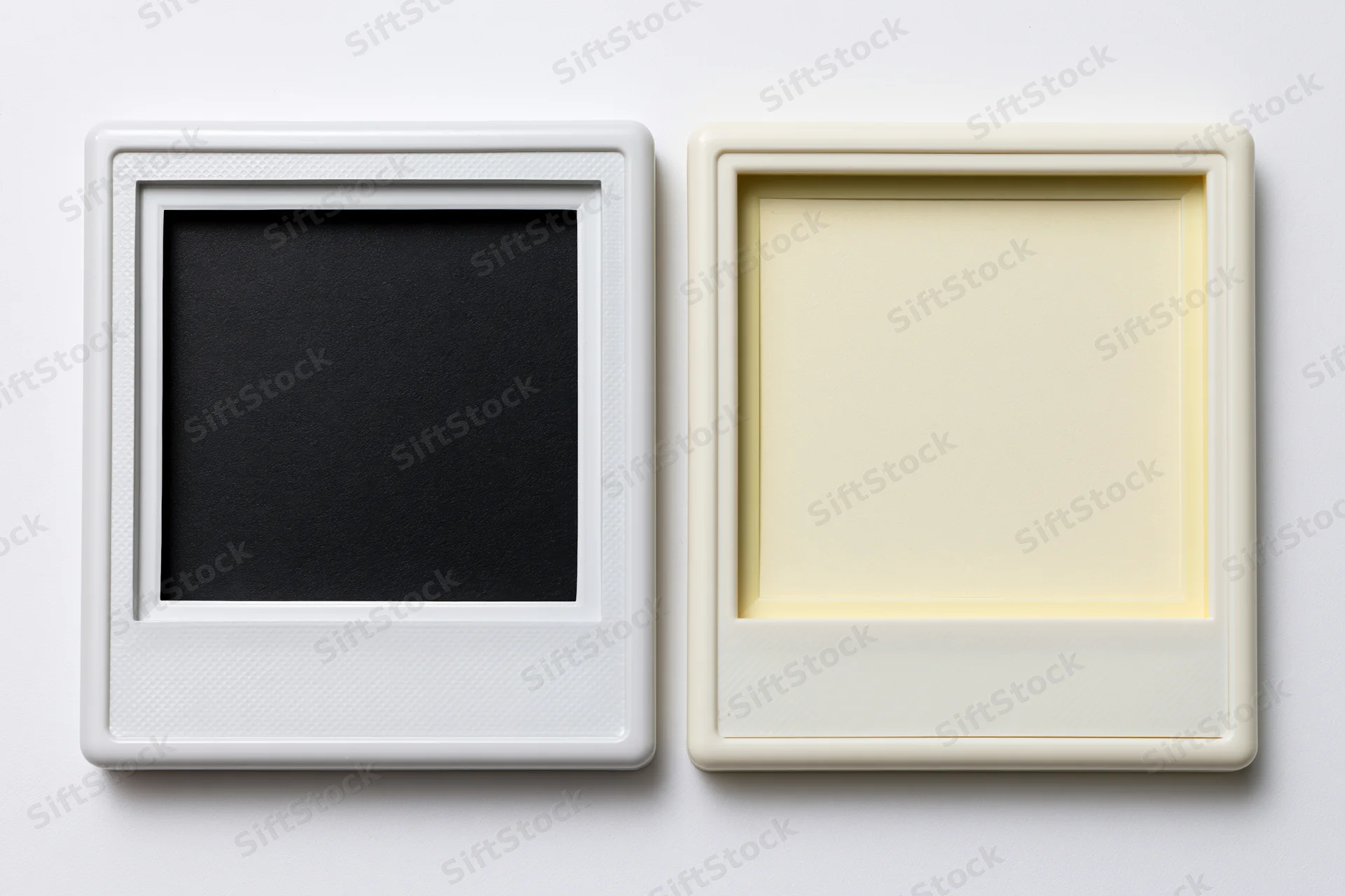 Two blank polaroid film frames side by side on white surface