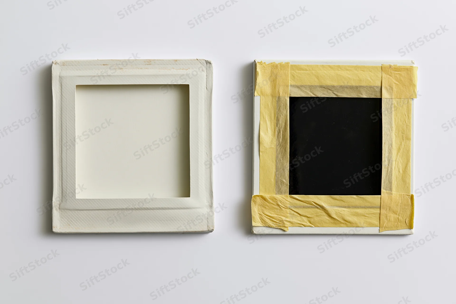 Two blank instant film photo prints side by side on white surface