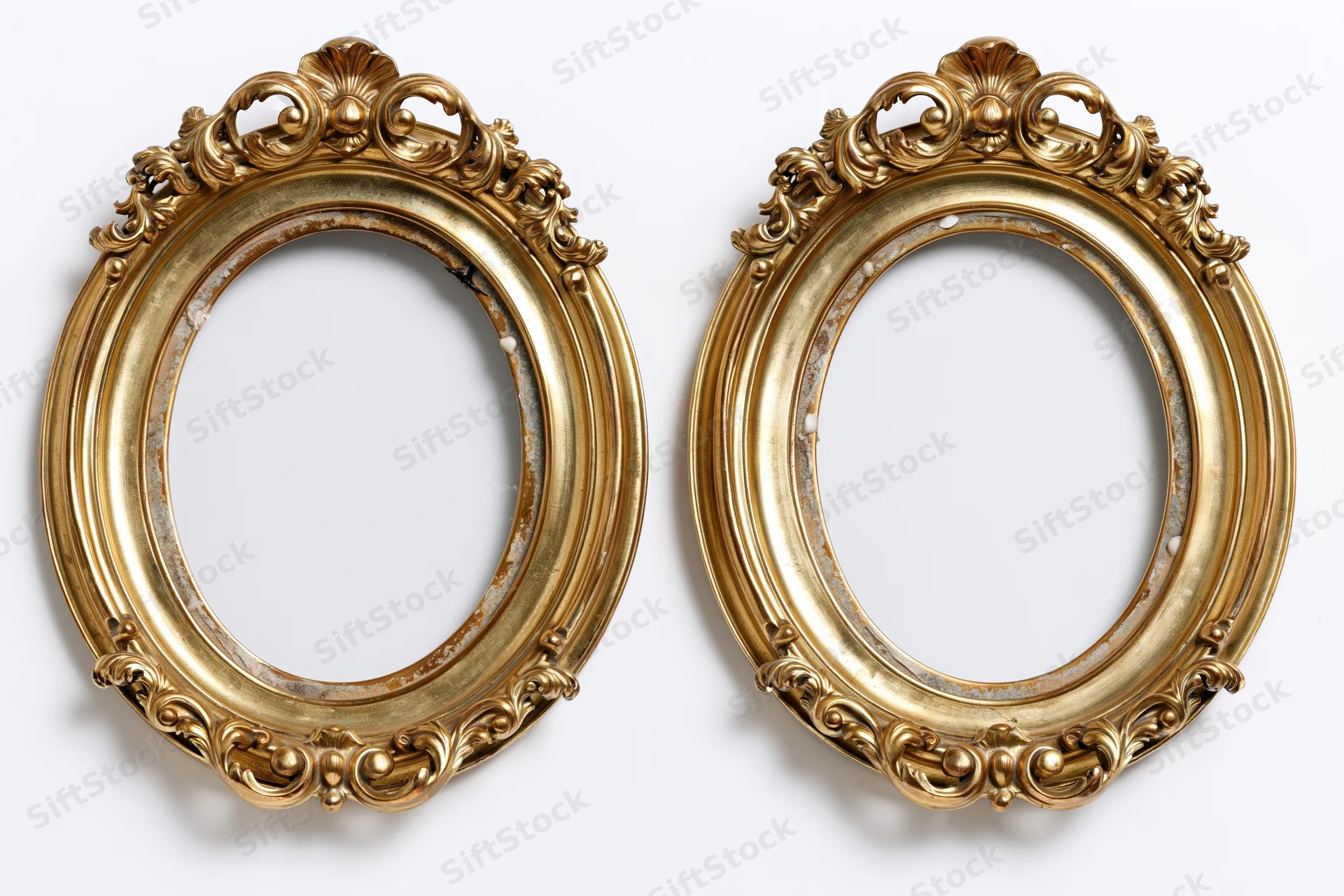 Two ornate oval gilded frames side by side on white background