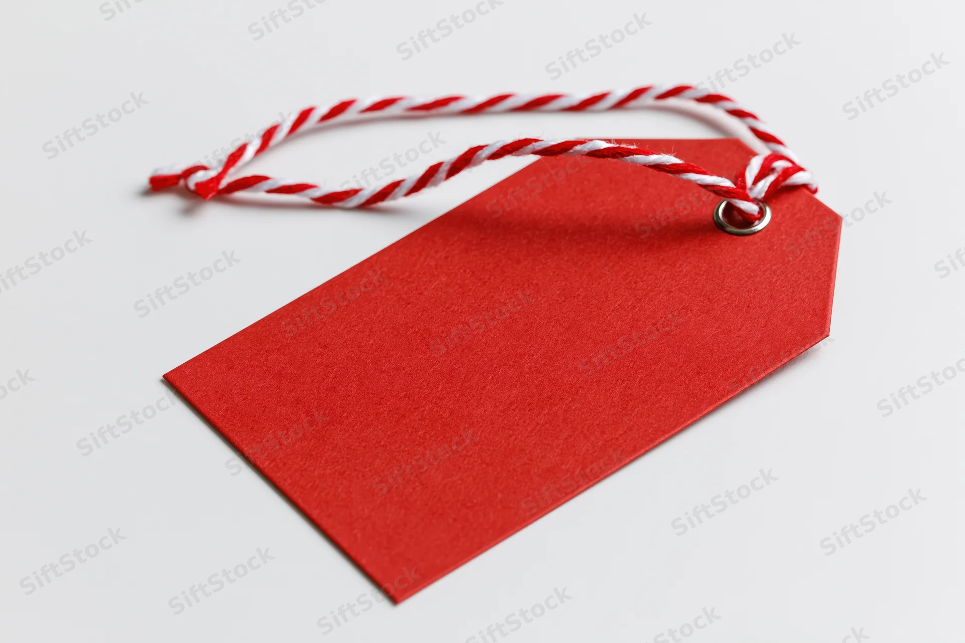 Blank red cardstock gift tag with red and white twisted string on white background