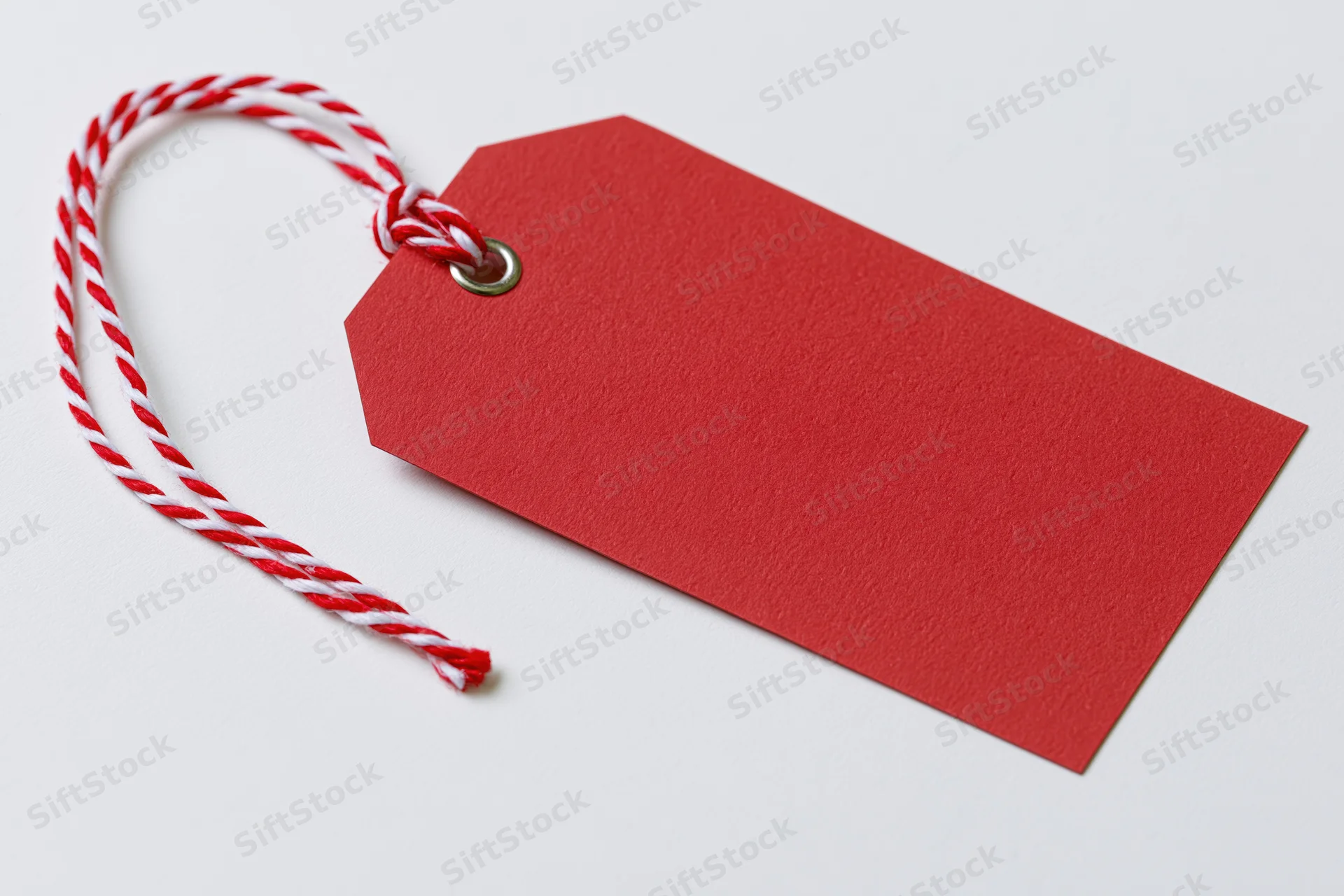 Blank red cardstock gift tag with red and white twisted string on white background